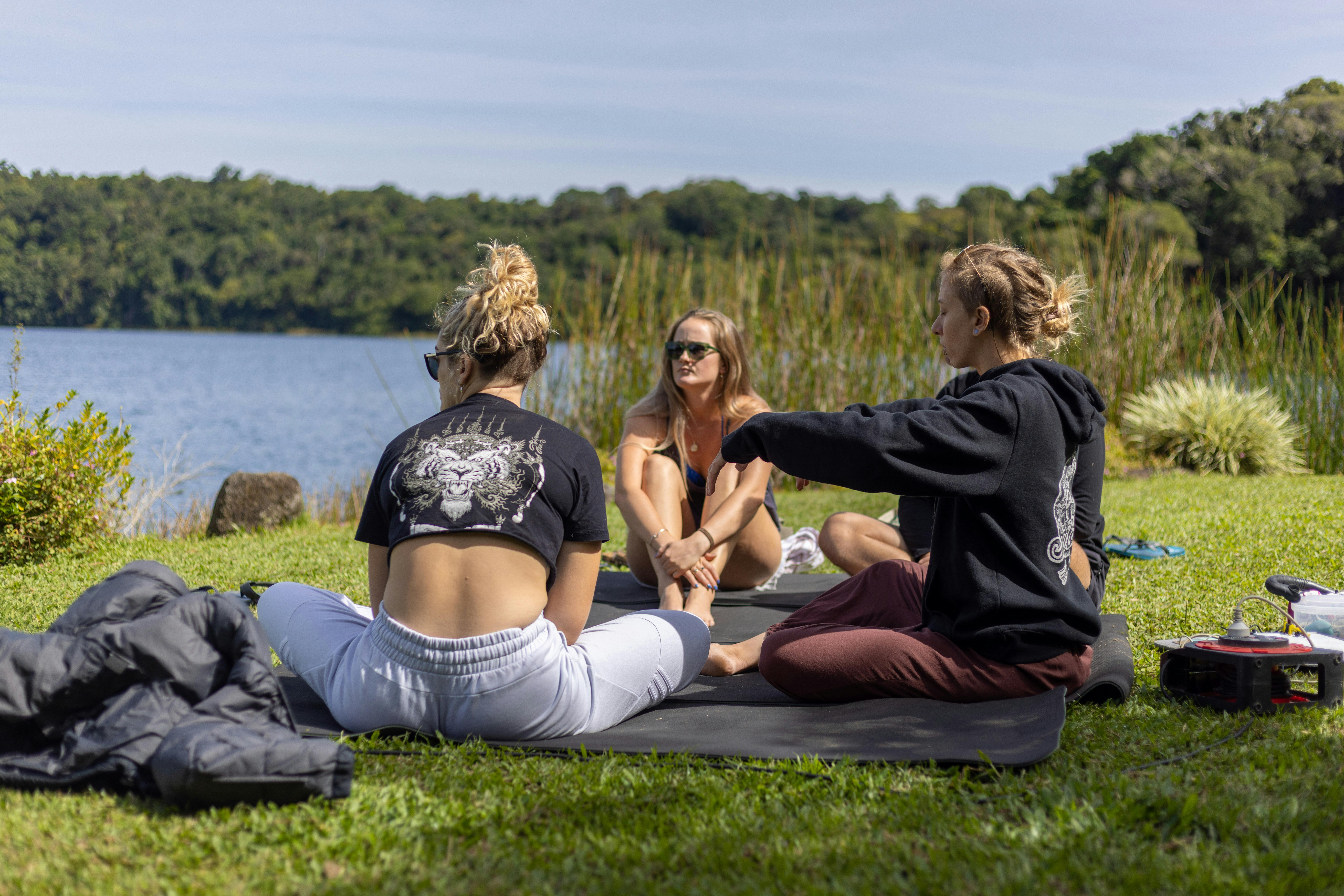Instructor Teaching theory to 3 students on the grass at Lake Barrine