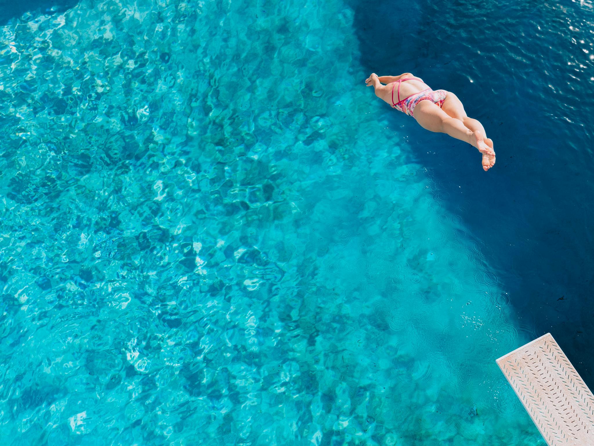A diver plunges towards the water