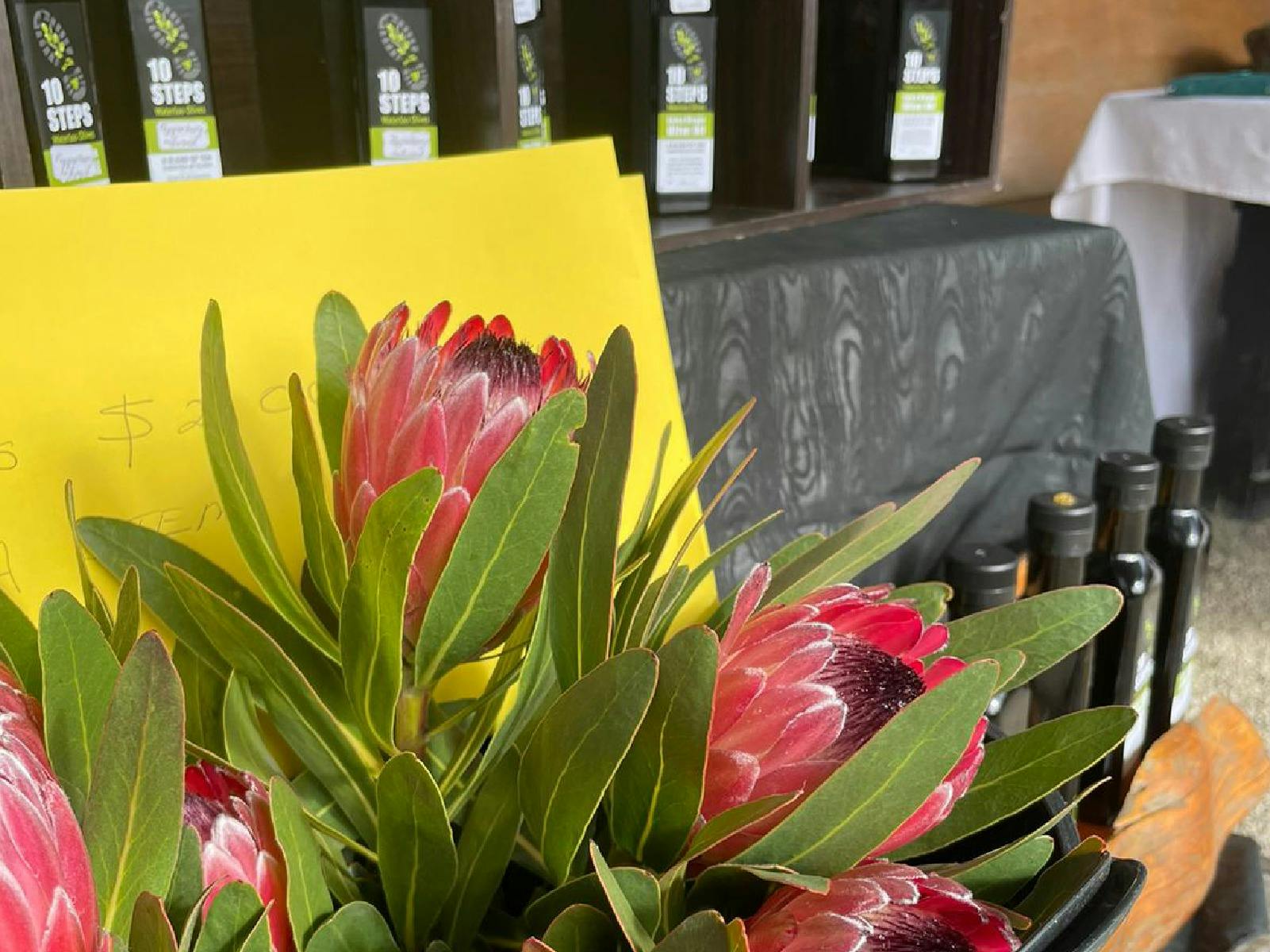 A close up shot of some beautiful flowers with olive oil in the background.