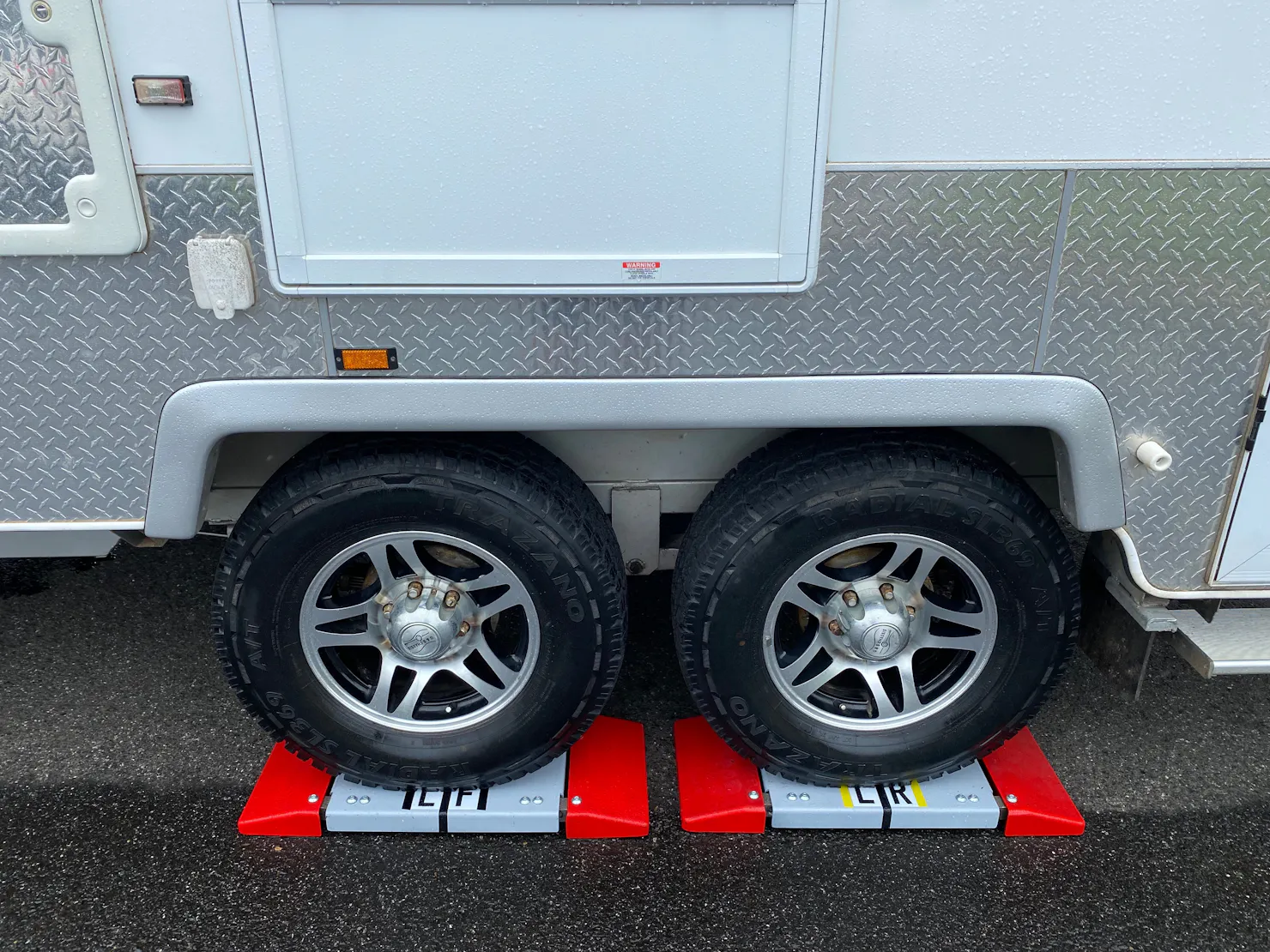 Dual axle caravan wheels on red drive on scales