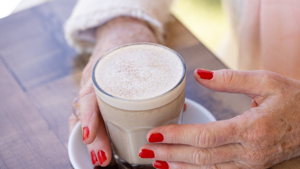 Cafe latte held in a ladys' hand