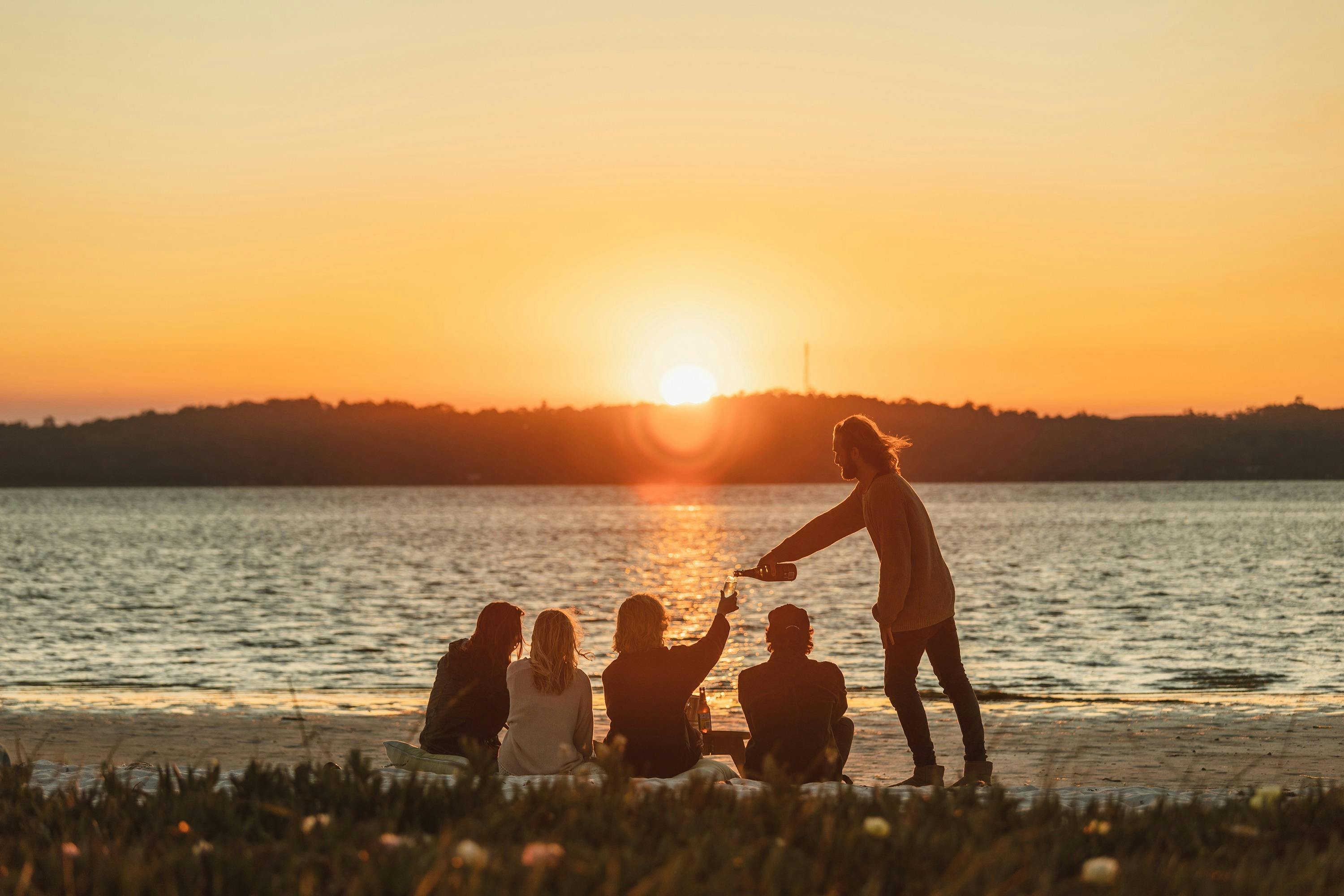 A ground of friends watching the sunset over Peel-Harvey Estuary from Herron Point Campground