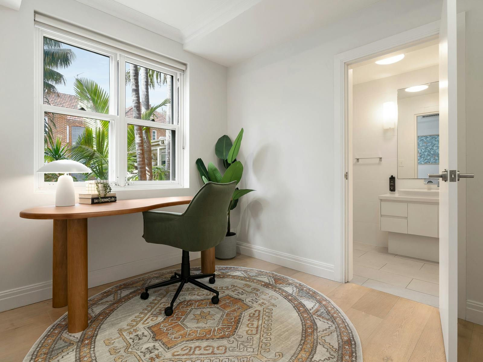 Brightly lit, dedicated study space with desk and green office chair facing a window.