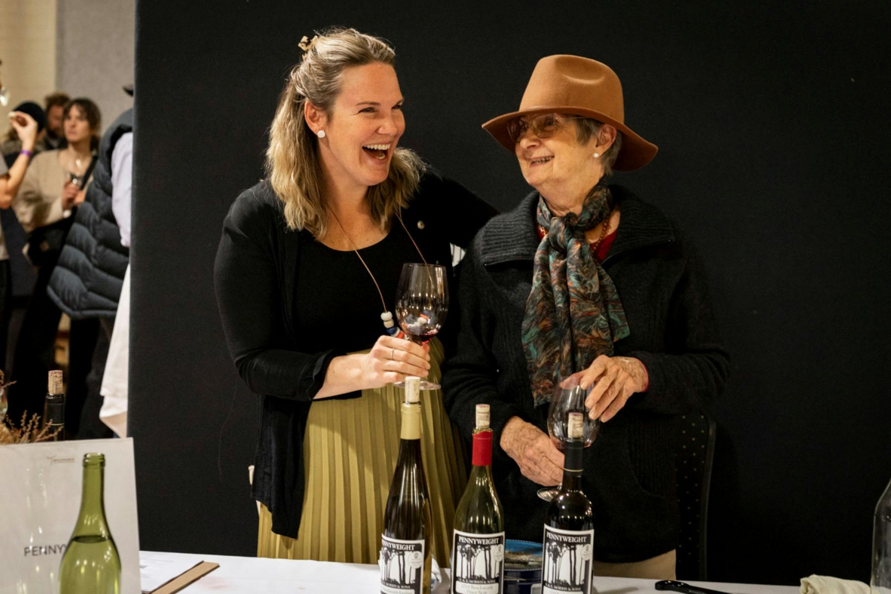 Two women smiling with wine glasses in their hands