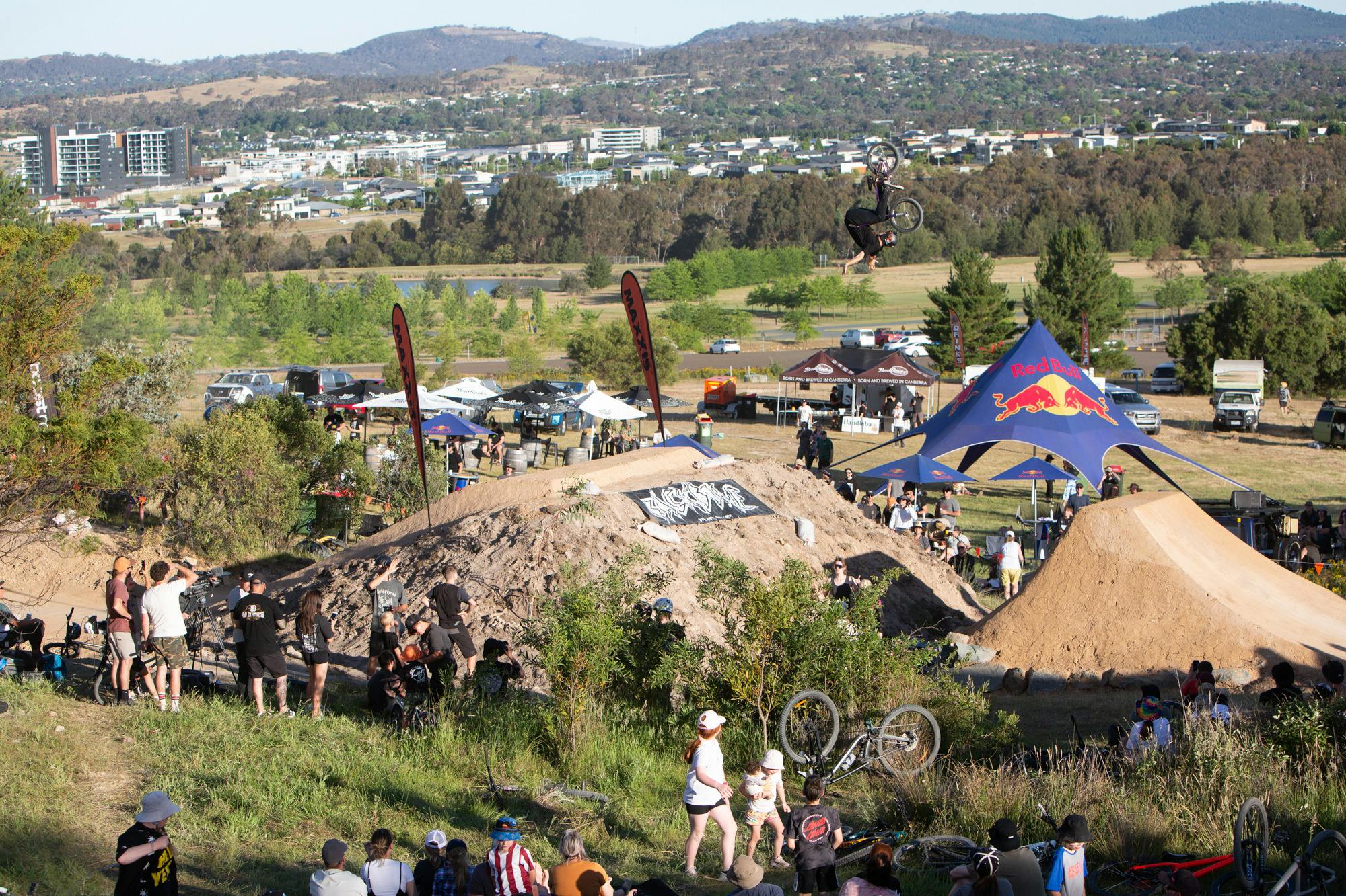 R Willy doing a front flip no hander over a big dirt jump as the crowd looks on