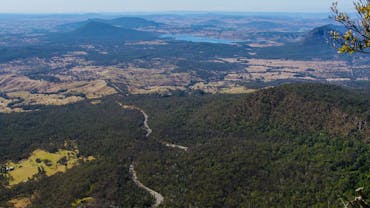 View of mountains, road, lake, farmland and forest.