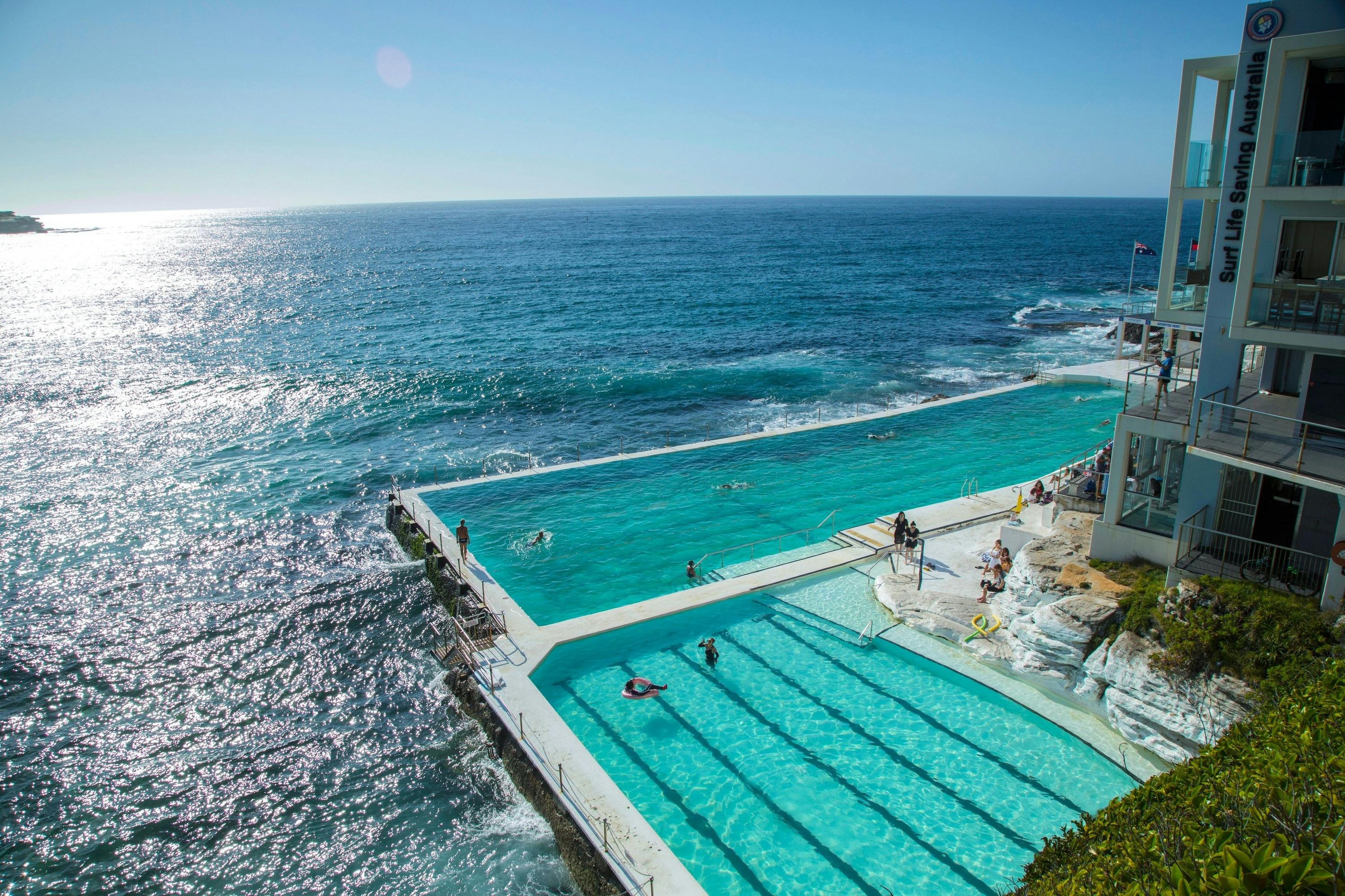 Swimmers at Bondi Icebergs ocean pool beside the Pacific Ocean.