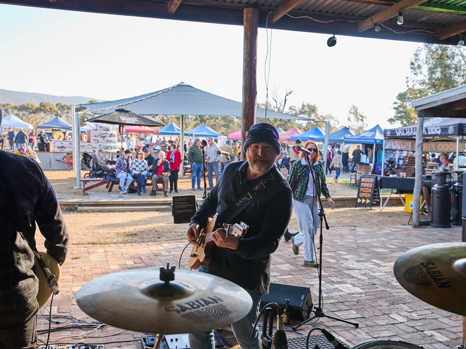 Musician Dave Nicholson playing outside at Barney's, from the drummers perspective out to the crowd