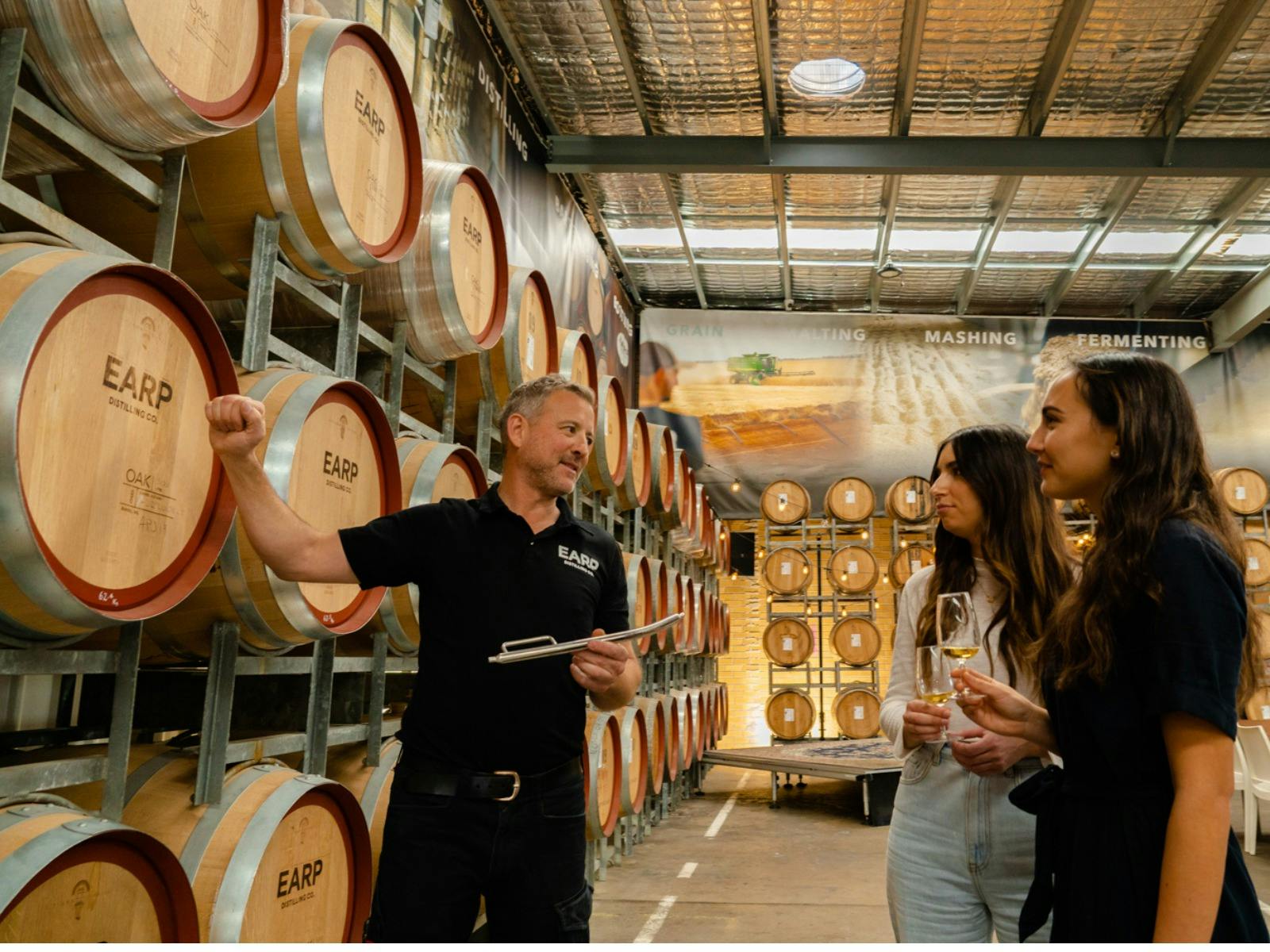 Man explaining the ageing process while pointing at a barrel