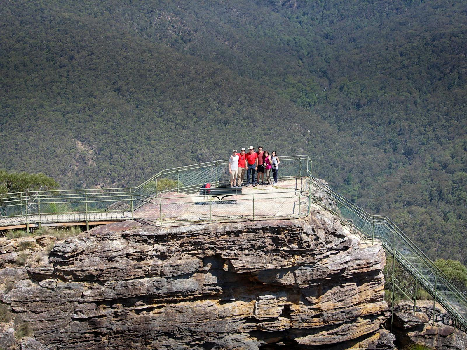 A group of walkers at a rocky outcrop overlooking the vast Grose Valley