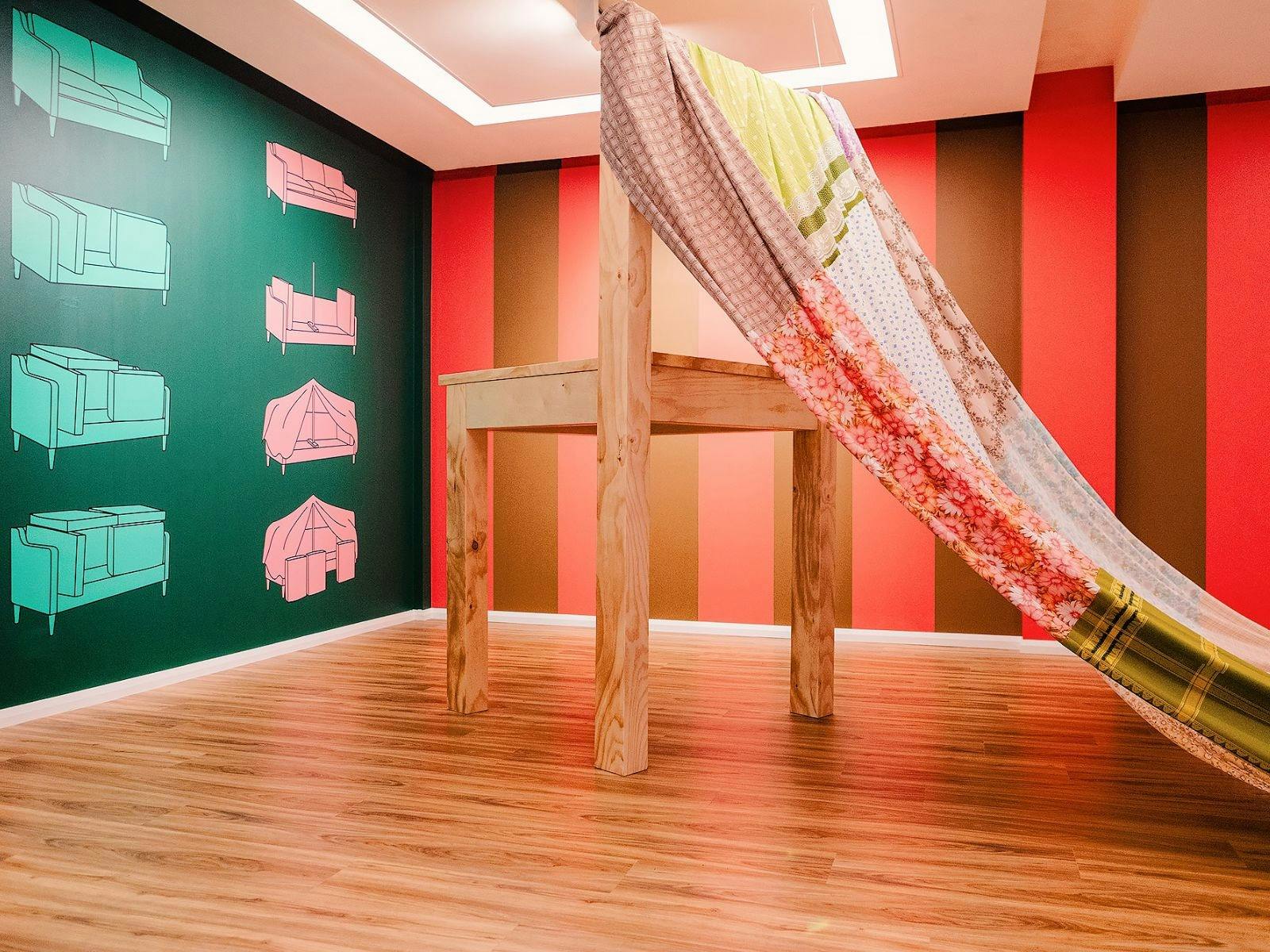 Floor to ceiling wooden chair, draped in colourful material