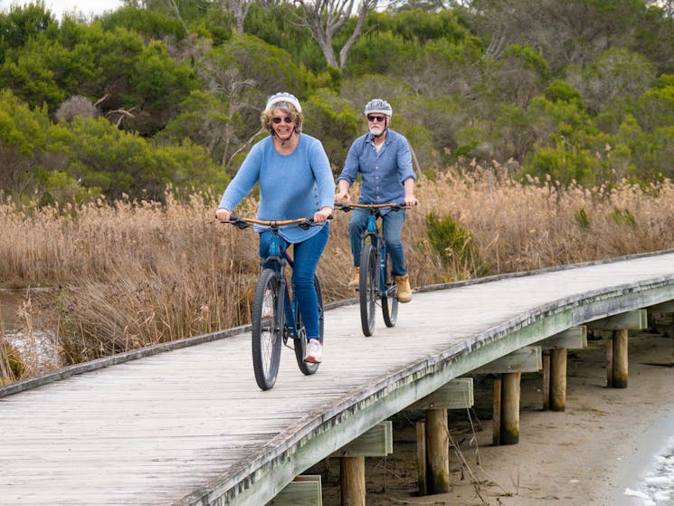 Two guests cycle along the board walk