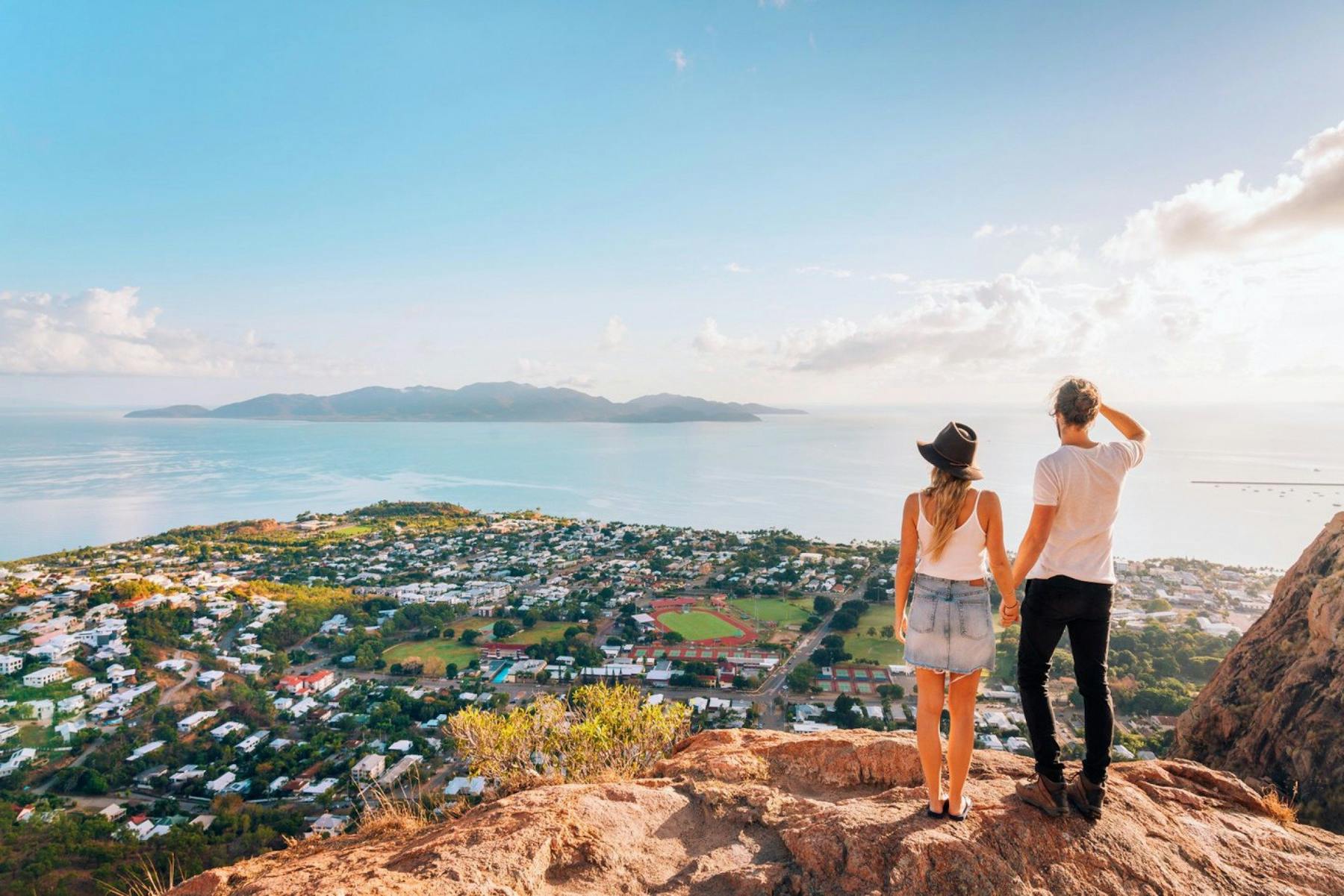 Two people on a hill looking out over a body of water