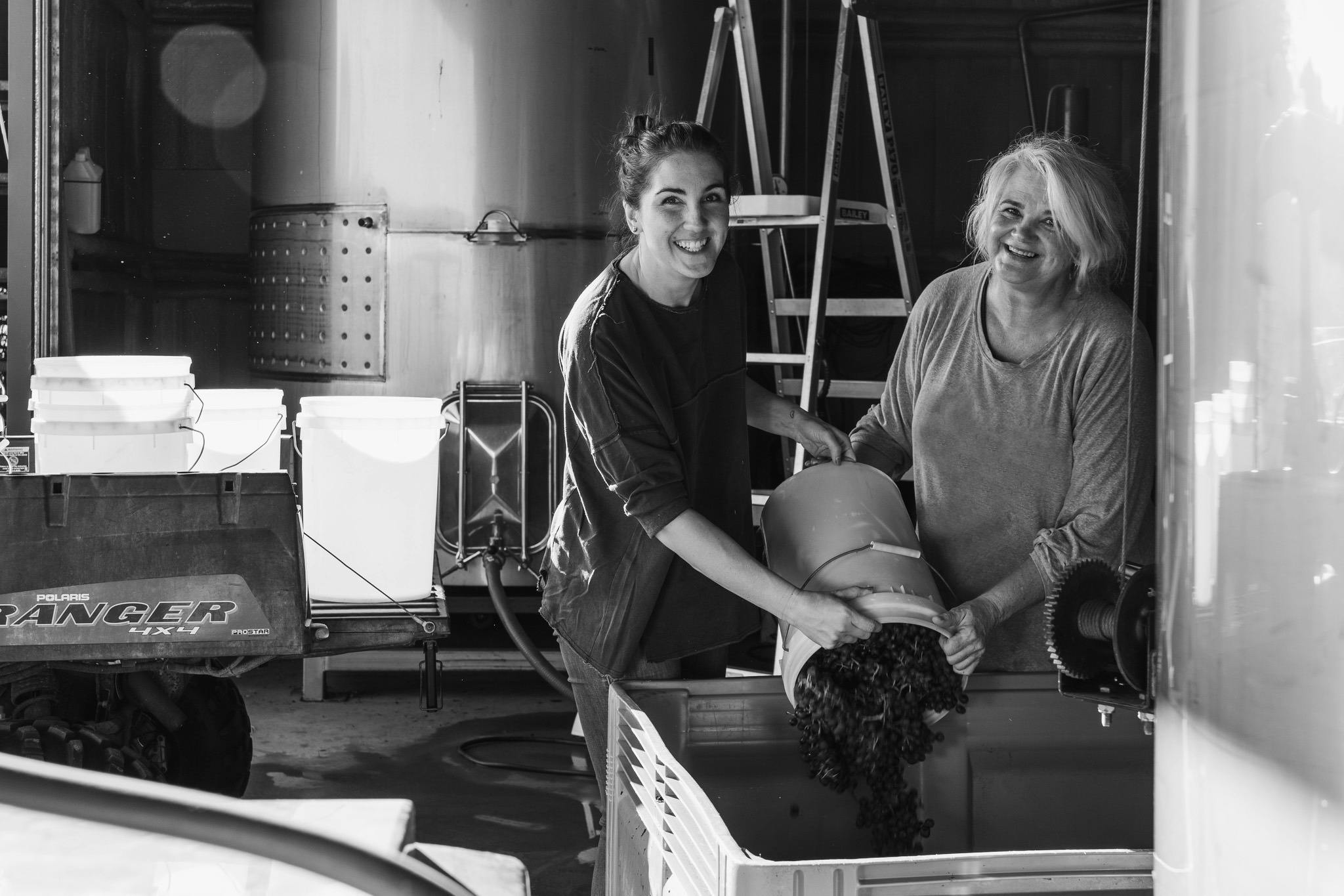 Jo & Allie working in the winery, bucketing grapes from the vineyard into fermentation bins
