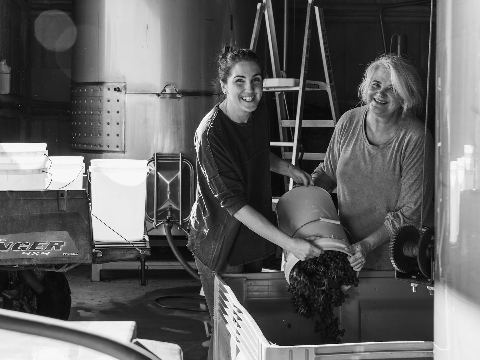 Jo & Allie working in the winery, bucketing grapes from the vineyard into fermentation bins