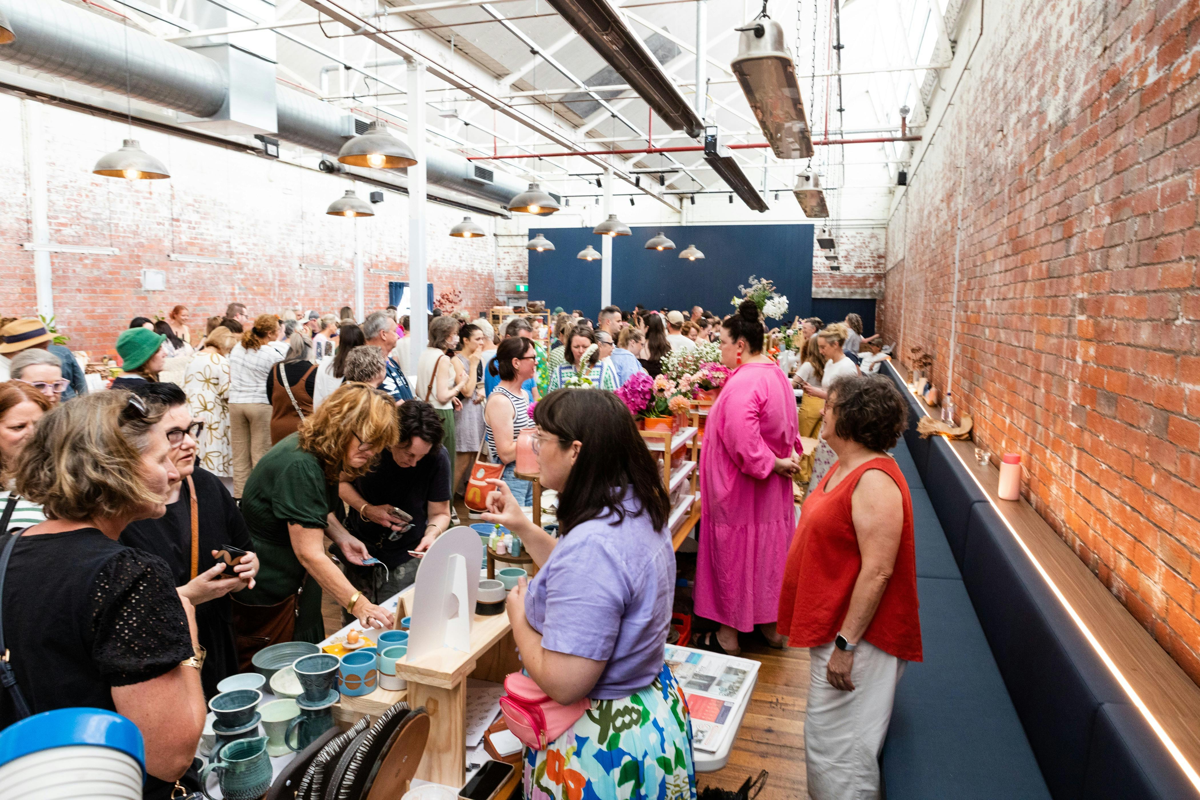 Crowds browsing handmade ceramics at the Geelong Ceramics Market inside Furphy Hall