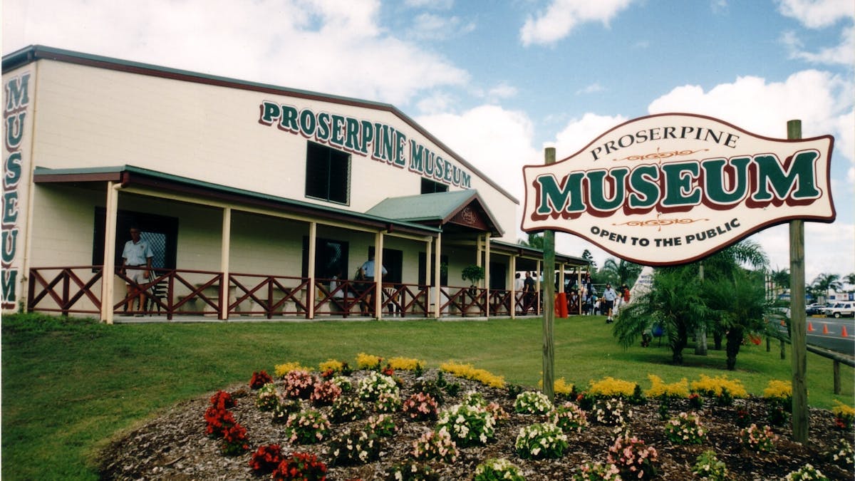An outside photo of the museum building with the  Museum sign in the front surrounded by flowerbeds