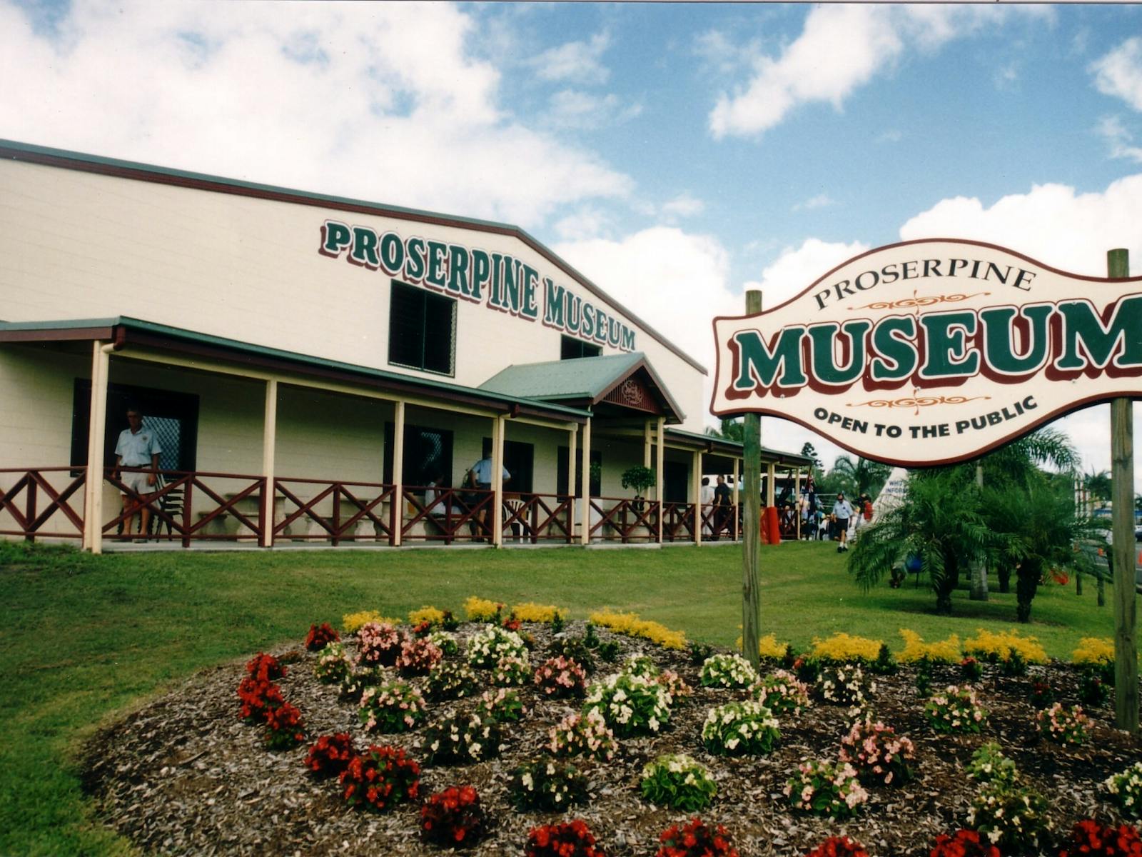 An outside photo of the museum building with the Museum sign in the front surrounded by flowerbeds An outside photo of the museum building with the Museum sign in the front surrounded by flowerbeds