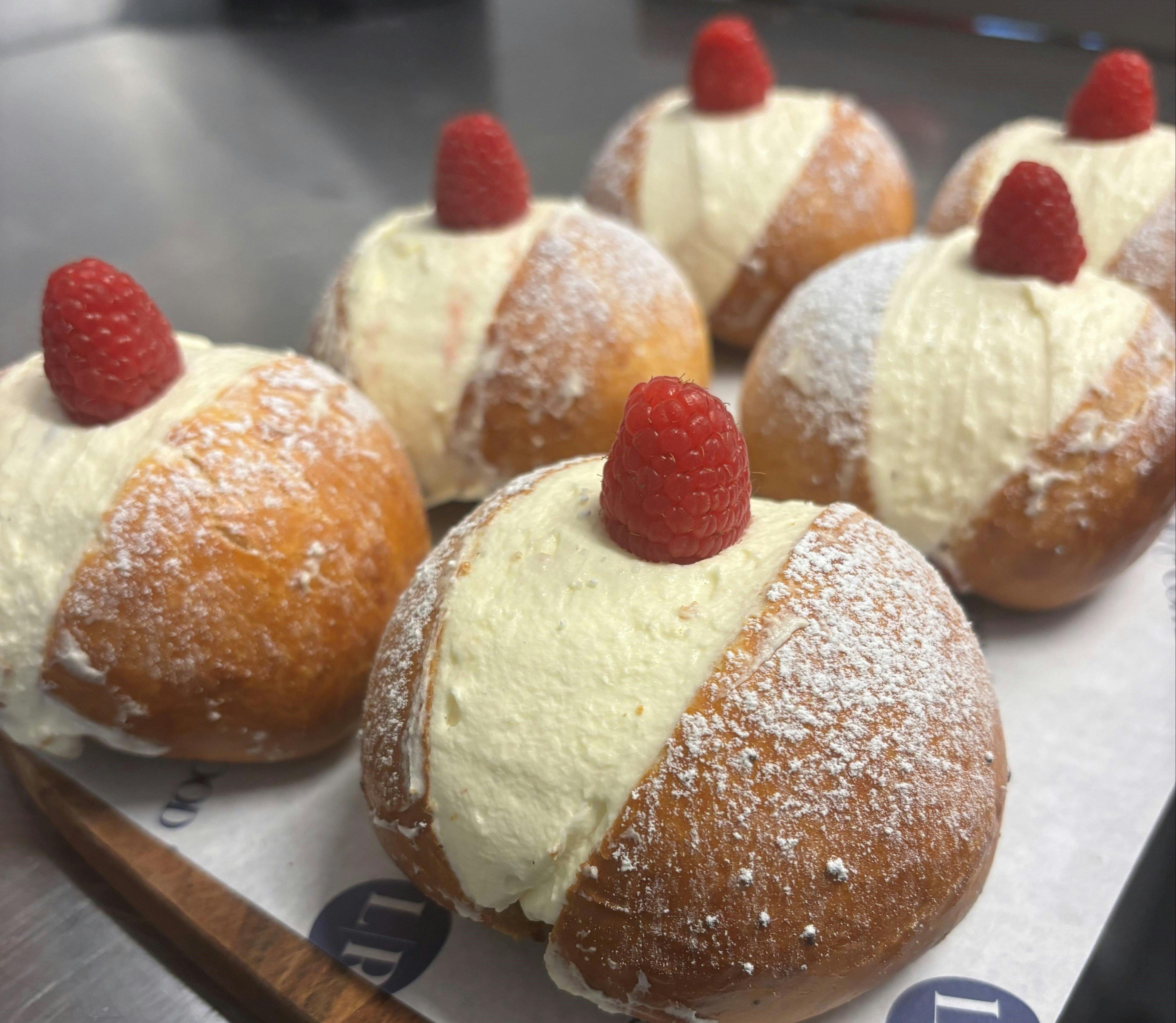 Cream pastries with raspberries on top