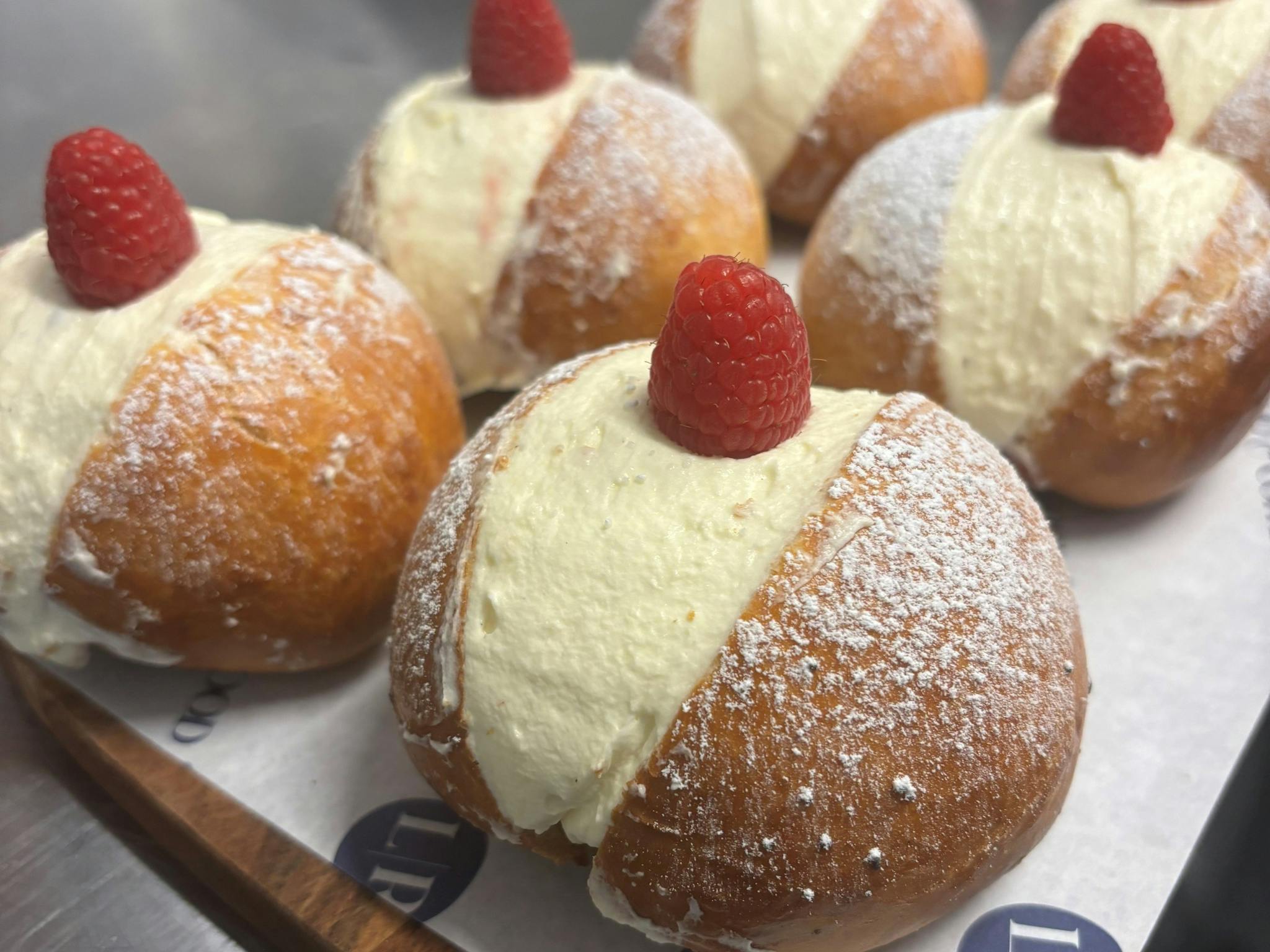 Cream pastries with raspberries on top