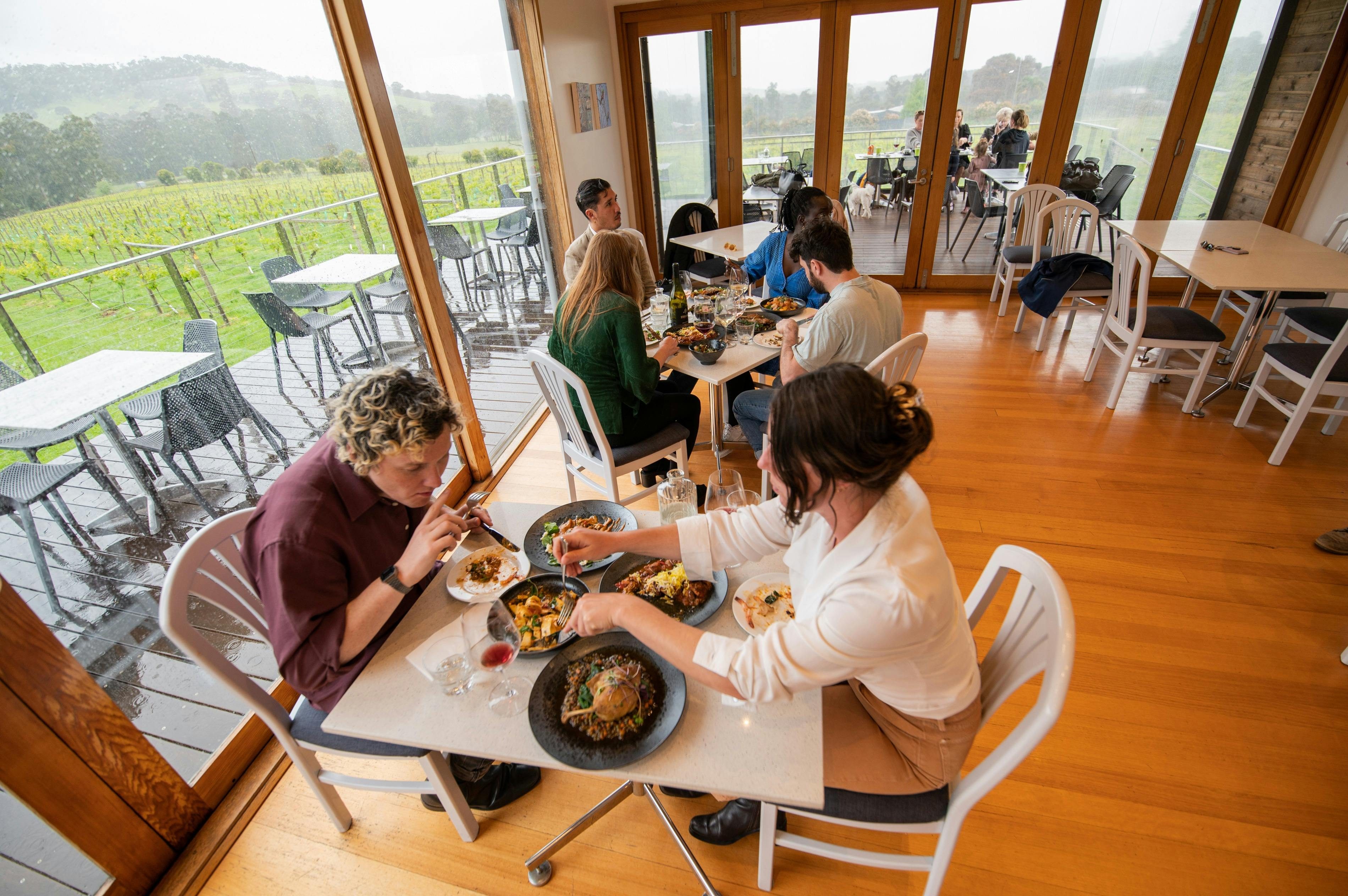 Guests dining inside the Steels Gate Wines restaurant in Dixons Creek overlooking the vineyard deck.