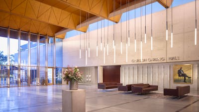 A shot of the brightly lit Gordon Darling Hall, including botanical arrangements and sleek seating.