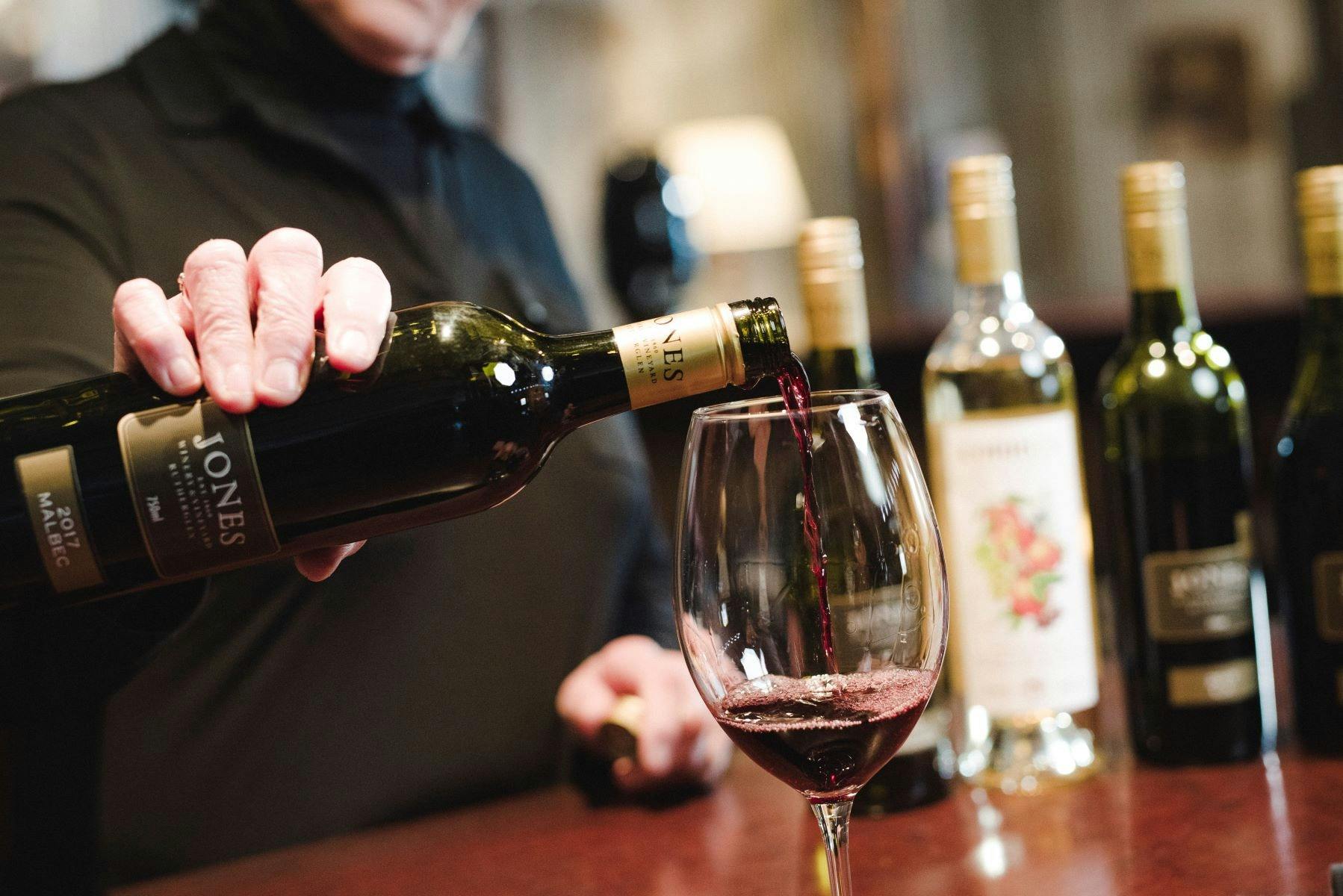 Red wine is poured into a wine glass