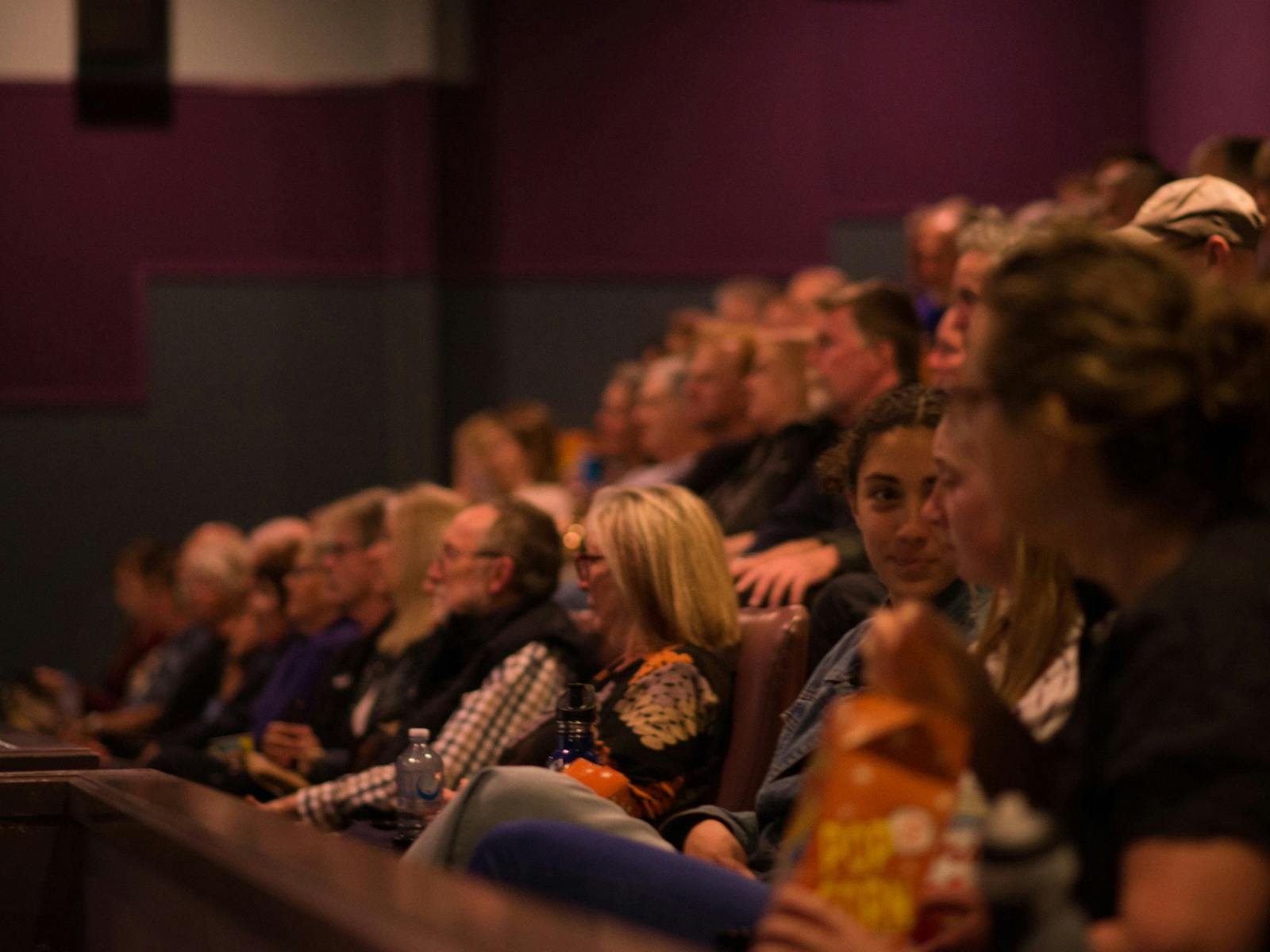 Seated crowd waits for film to start