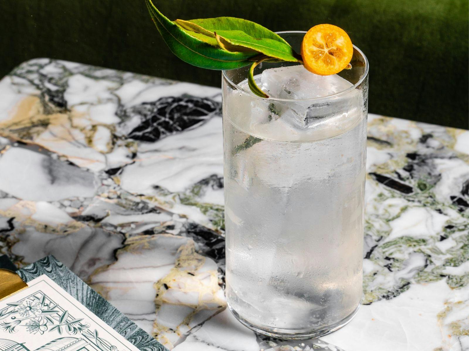 高腳玻璃清澈雞尾酒，點綴金桔