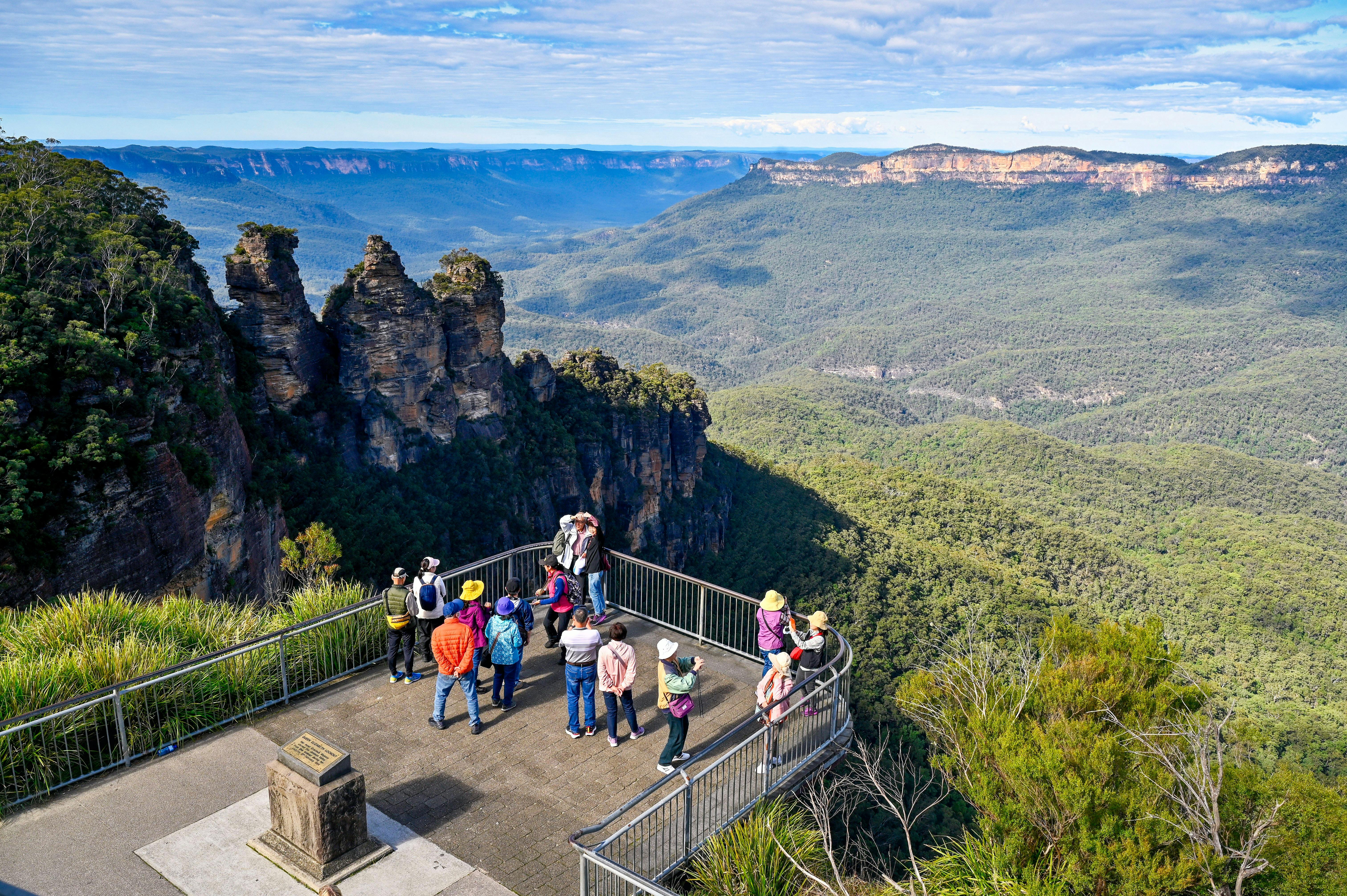 A group of visitors at Echo Point lookout, with the Three Sisters rock formation in the background