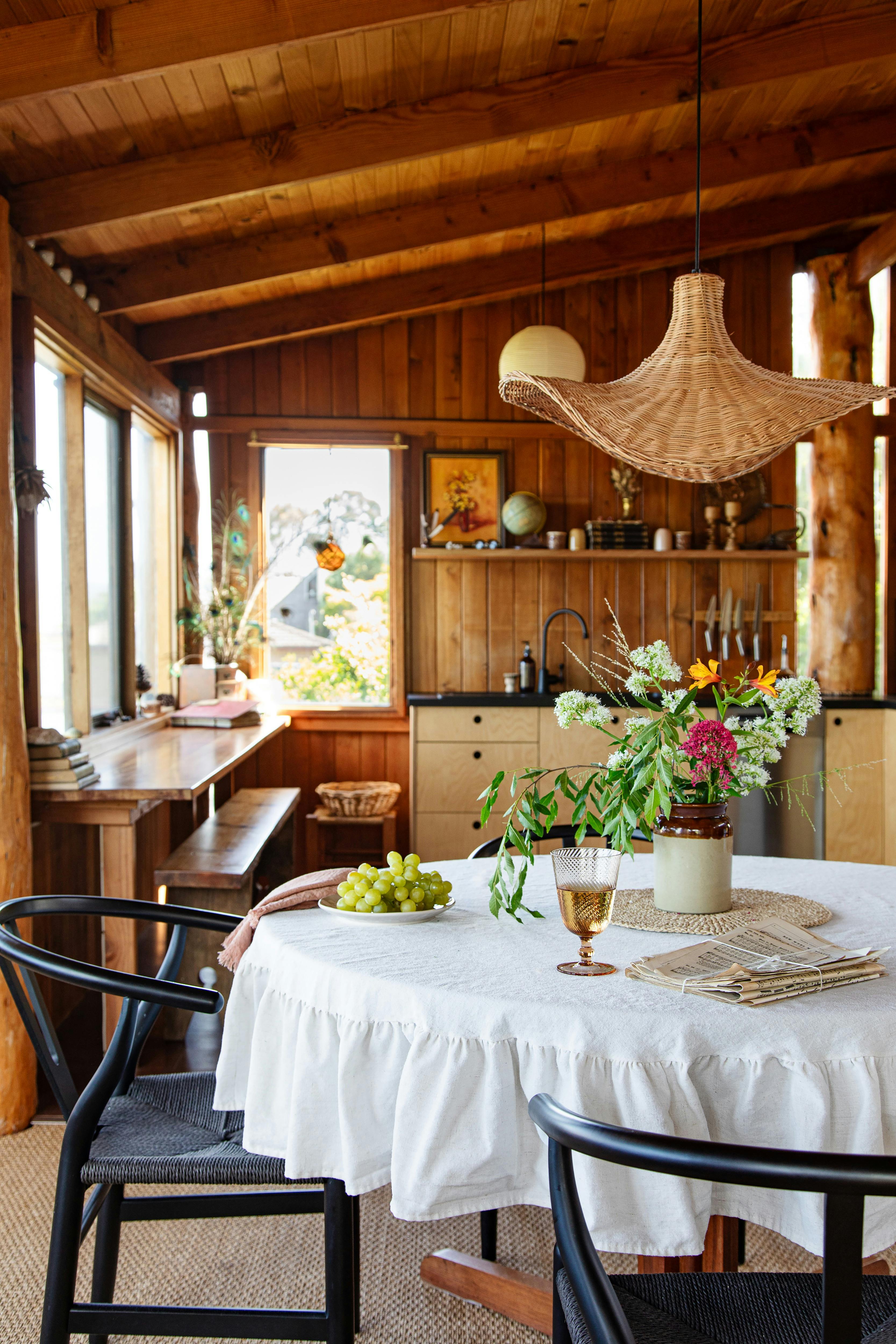 A wooden kitchen with sink and bench seat along the window