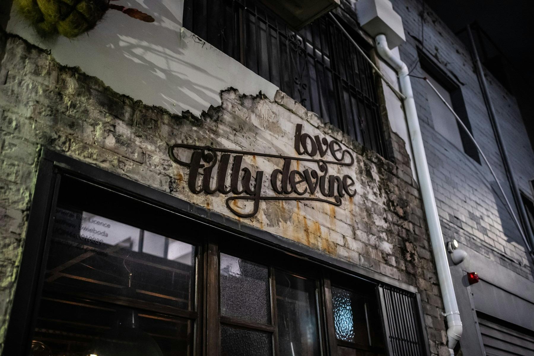 Rustic brick facade with sign reading 'Love, Tilly Devine'