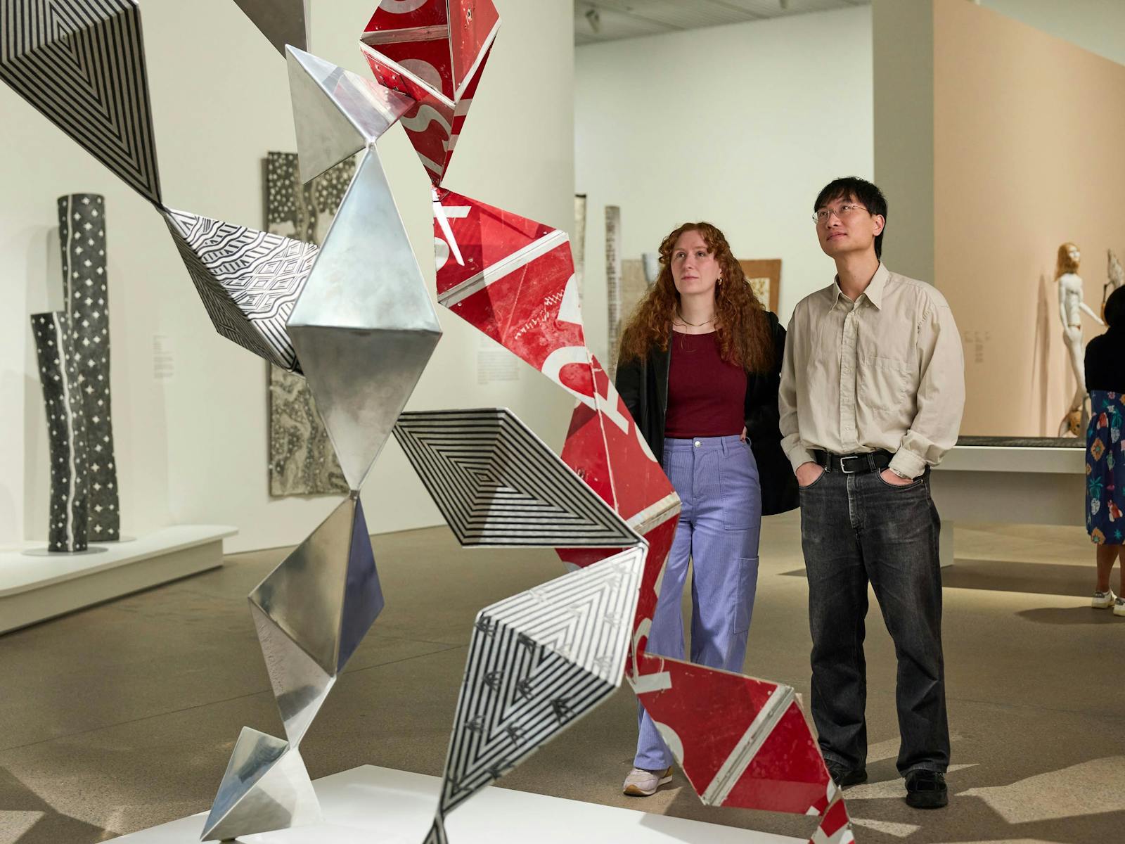A person and person standing next to a sculpture