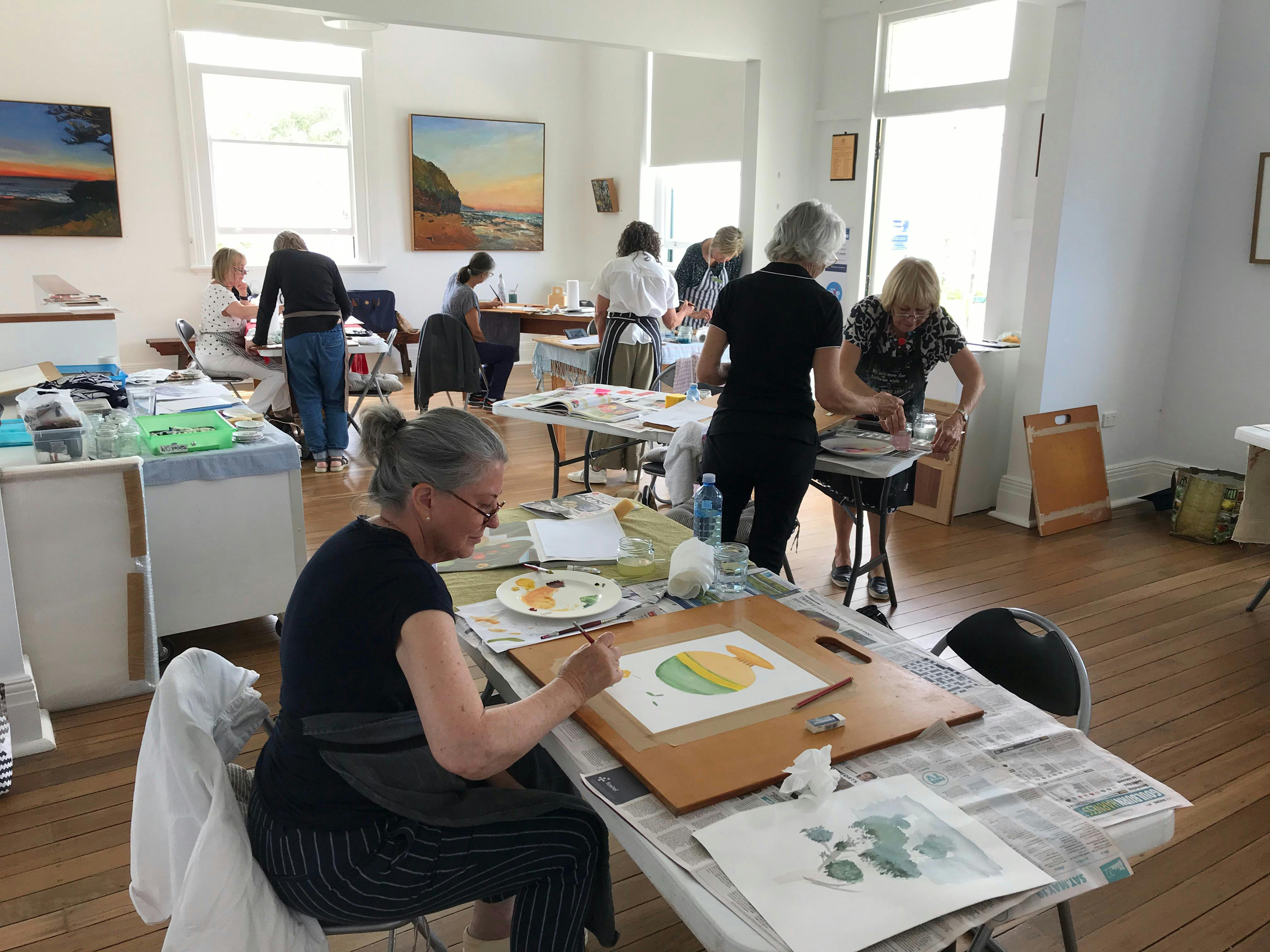 人々のグループがアートワークショップに参加します。