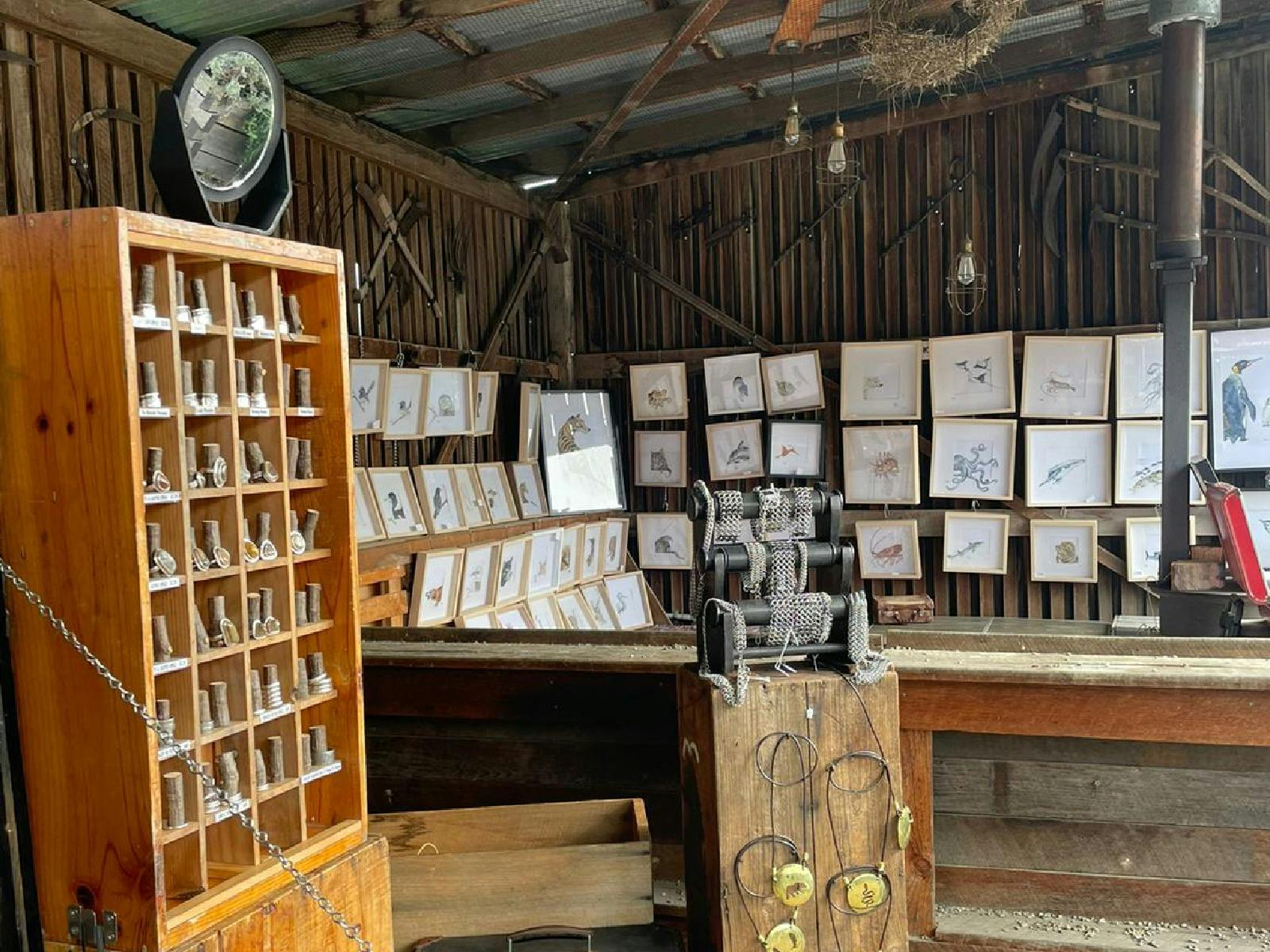 A stall within the barn selling metalwork/jewelry, with an art store in the back.