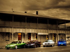 A view of The Austral Inn Hotel with four cars parked in front of the venue