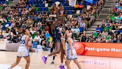UC Capitals player driving to the basket for a layup during a WNBL game.