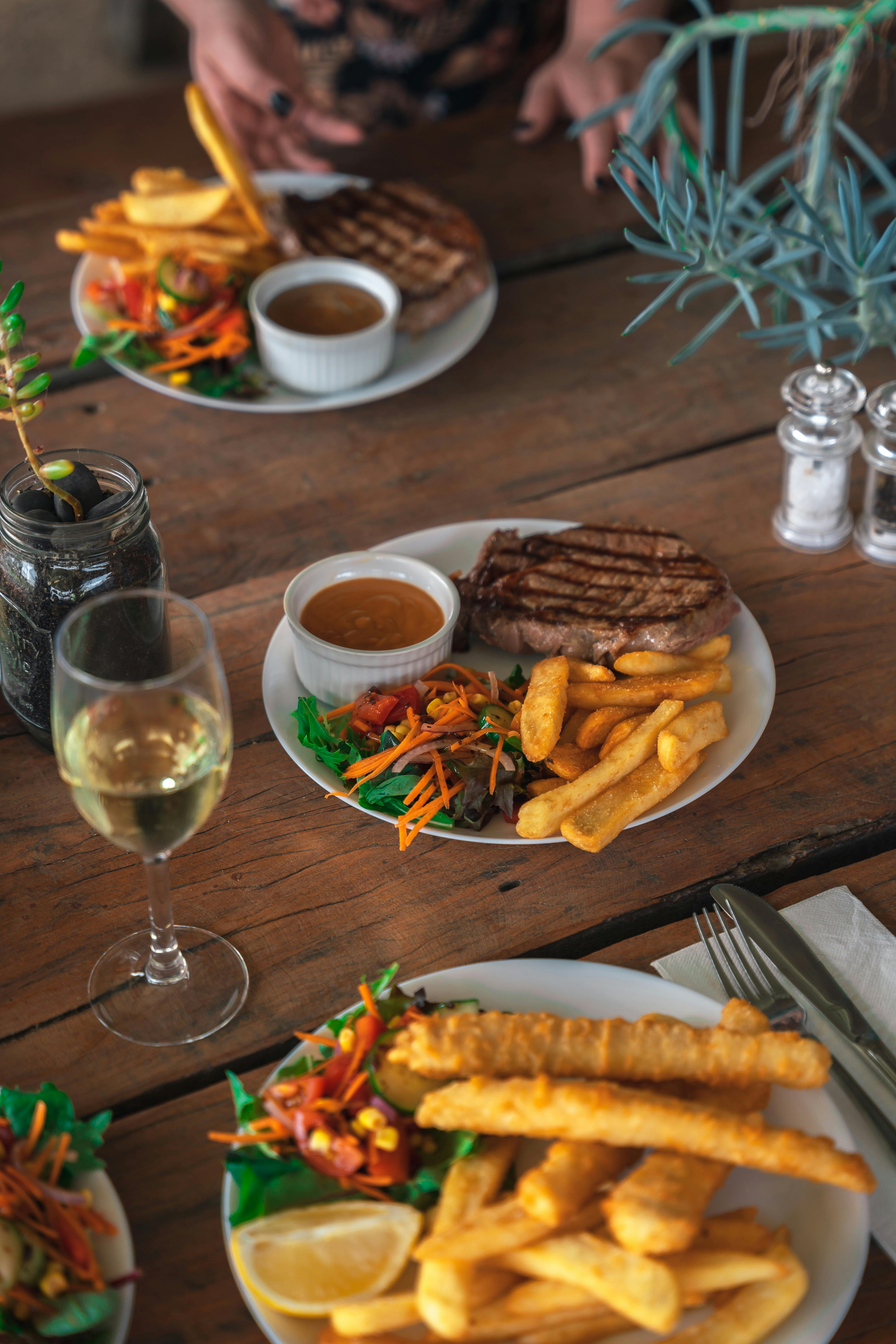 A plate of food and class of white wine