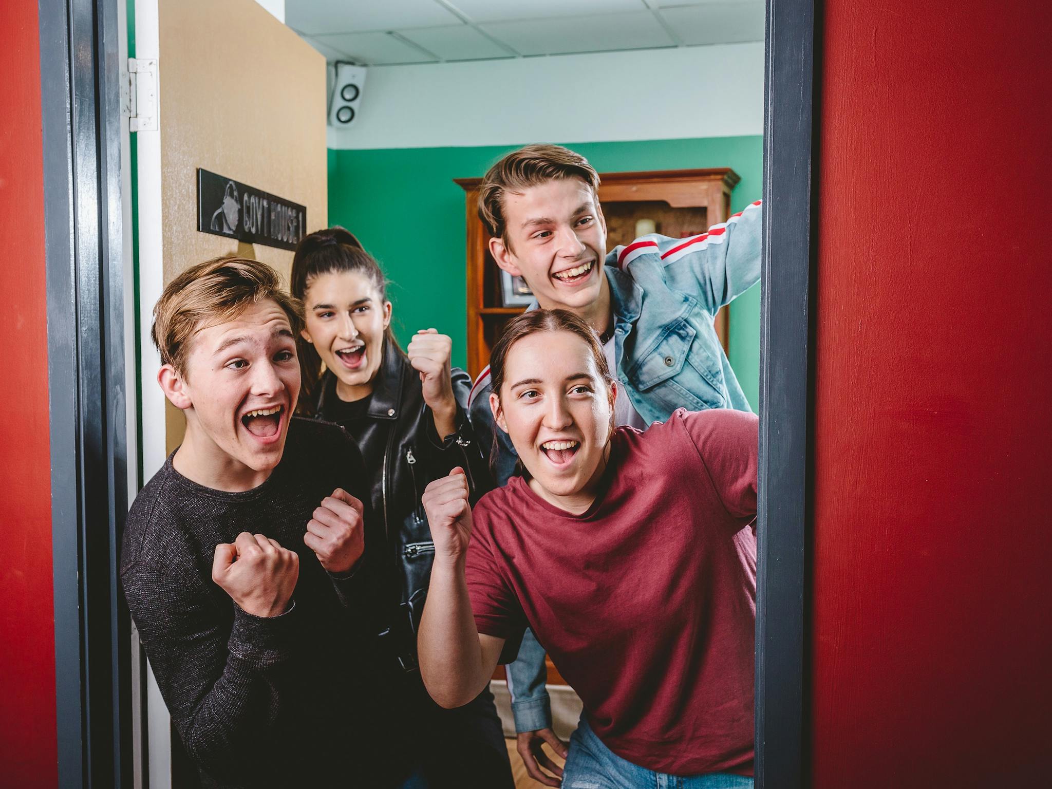 Group of 4 cheering as they break out of the escape room Group of 4 cheering as they break out of the escape room