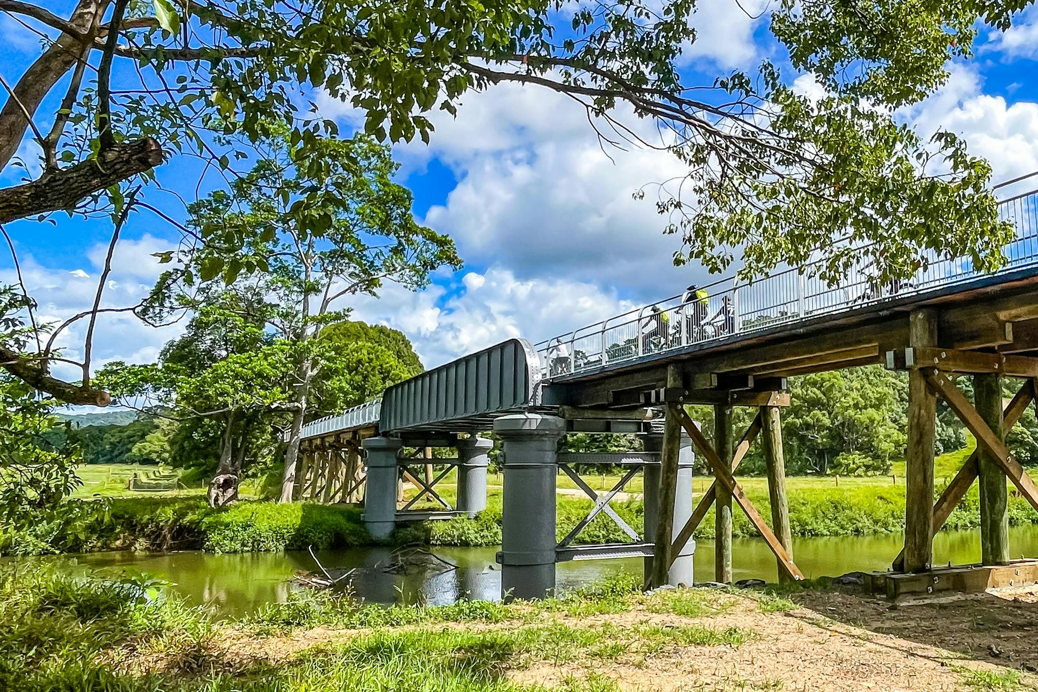 Northern Rivers Rail Trail에서 철교를 건너는 E자전거 그룹의 측면 보기