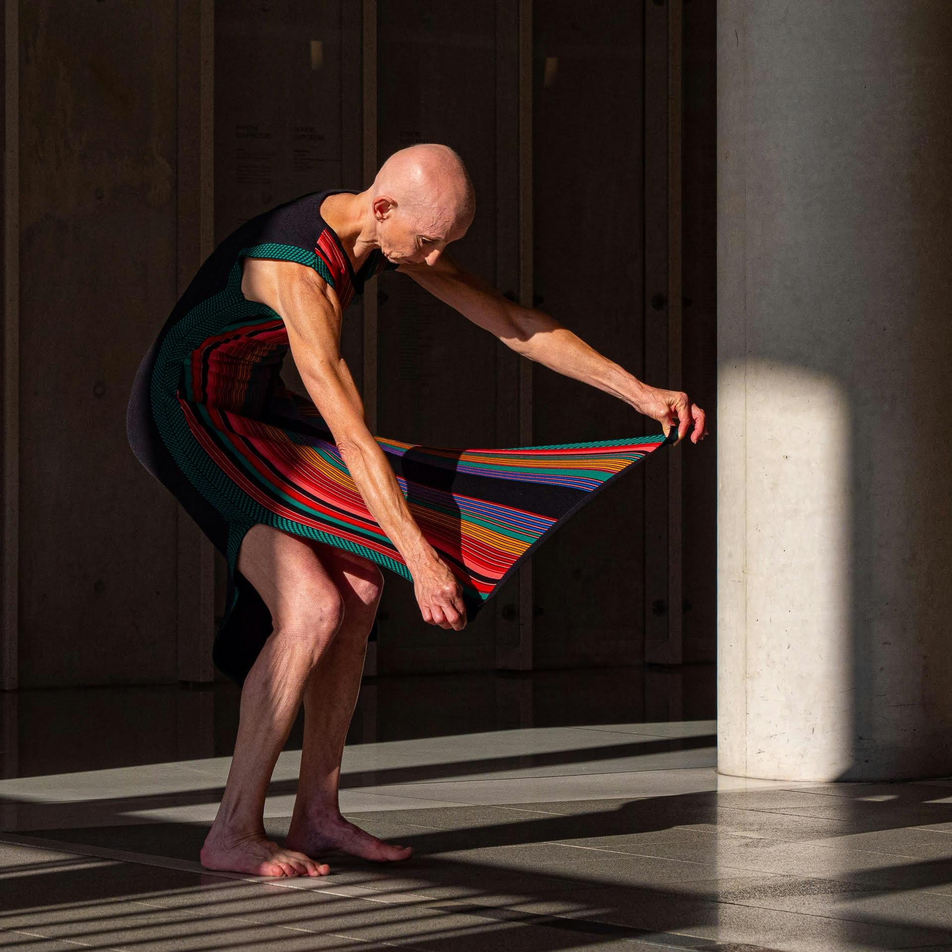 bald woman holds out striped skirt