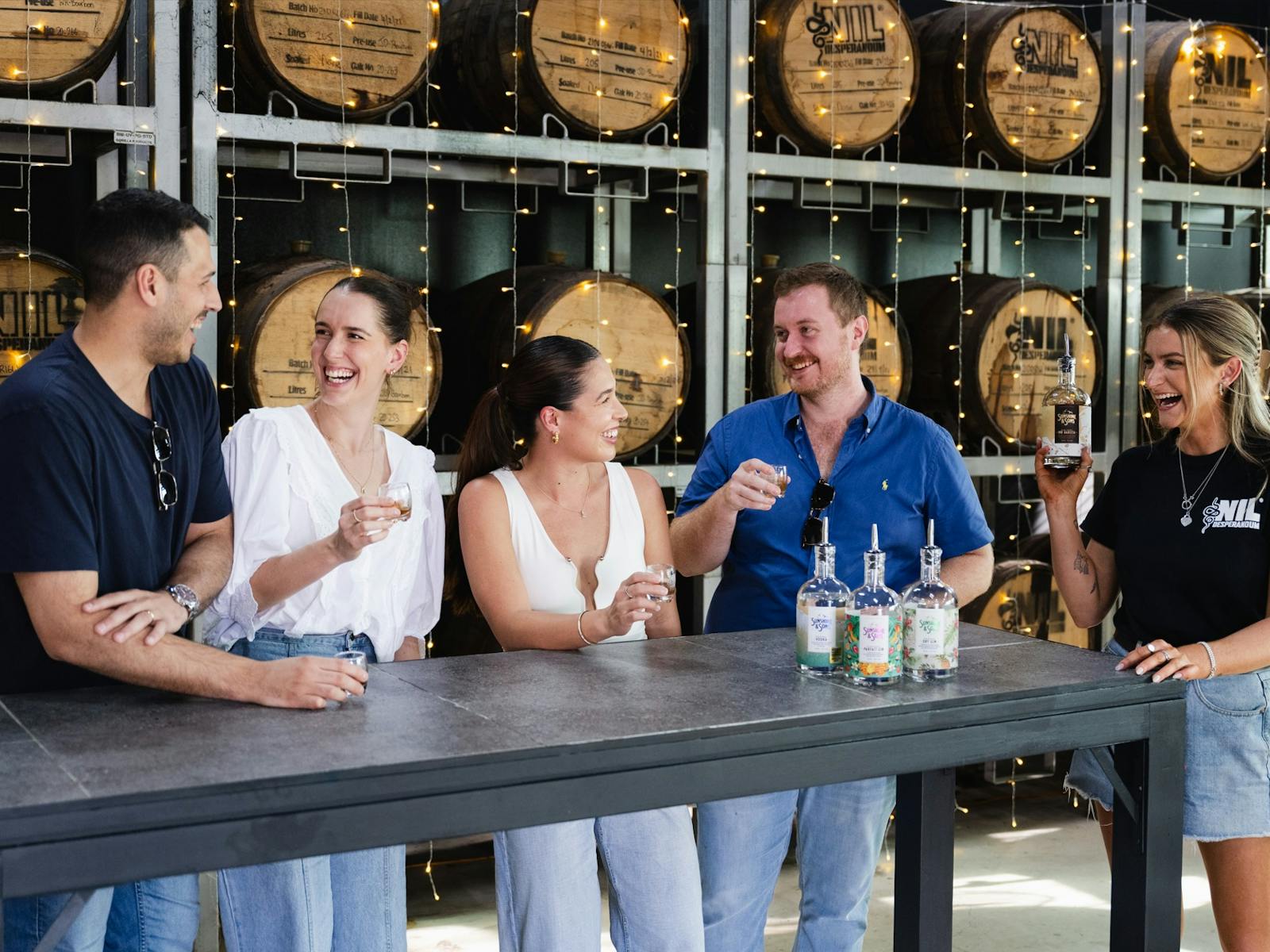 Group of friends laughing whilst tasting spirits