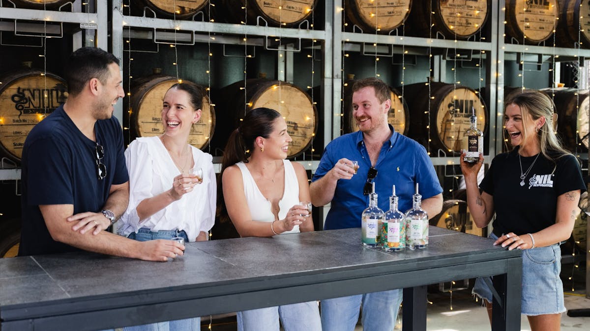 Group of friends laughing whilst tasting spirits
