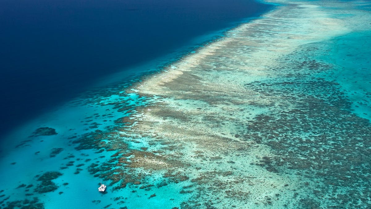 Long reef system, dark blue water coming up to shallow light blue water and reef