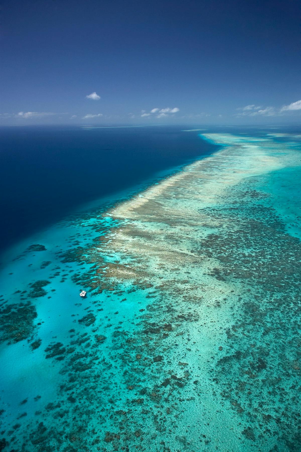 Long reef system, dark blue water coming up to shallow light blue water and reef