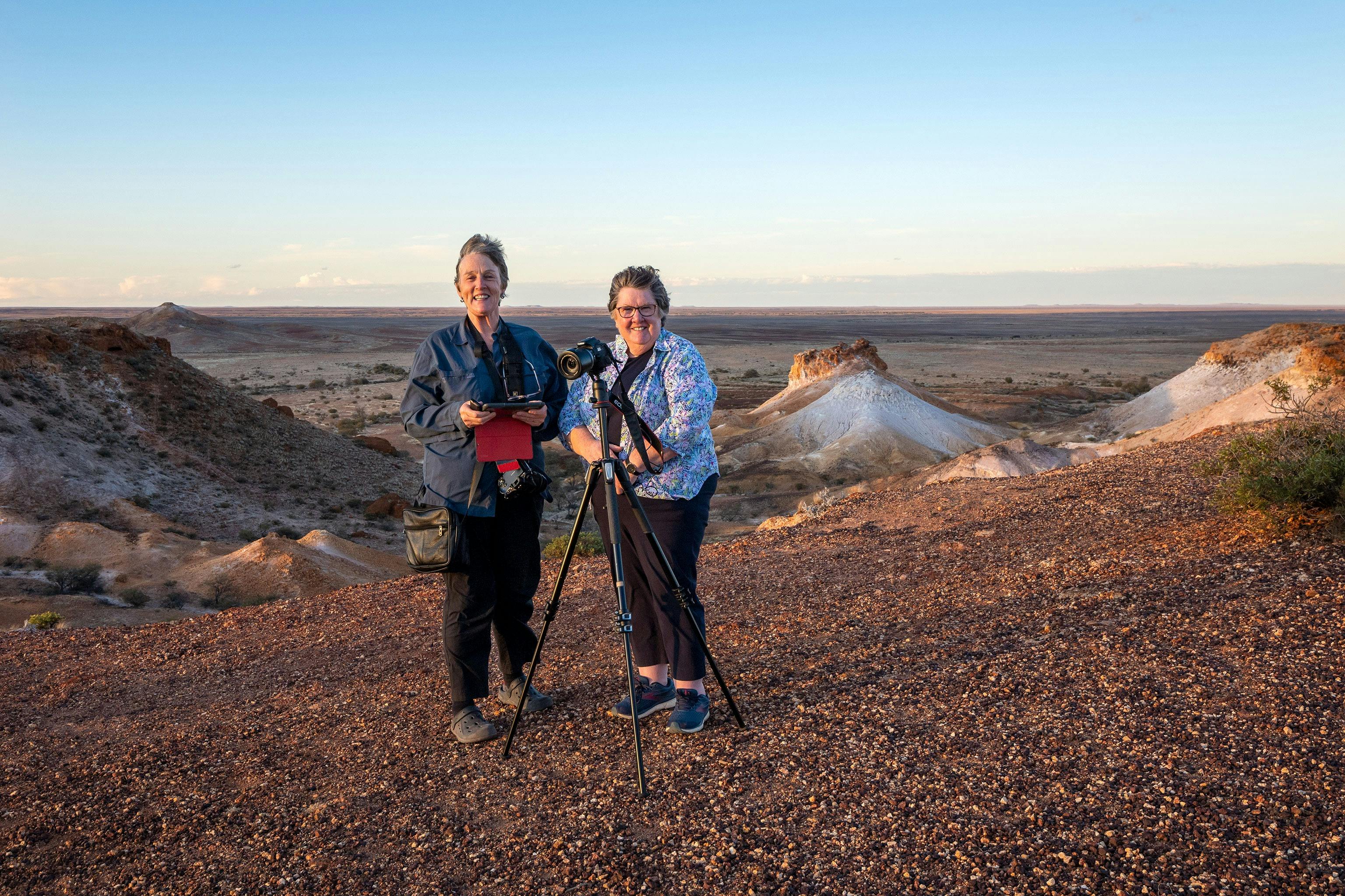 Two women with cameras  with the Breakaways behind them