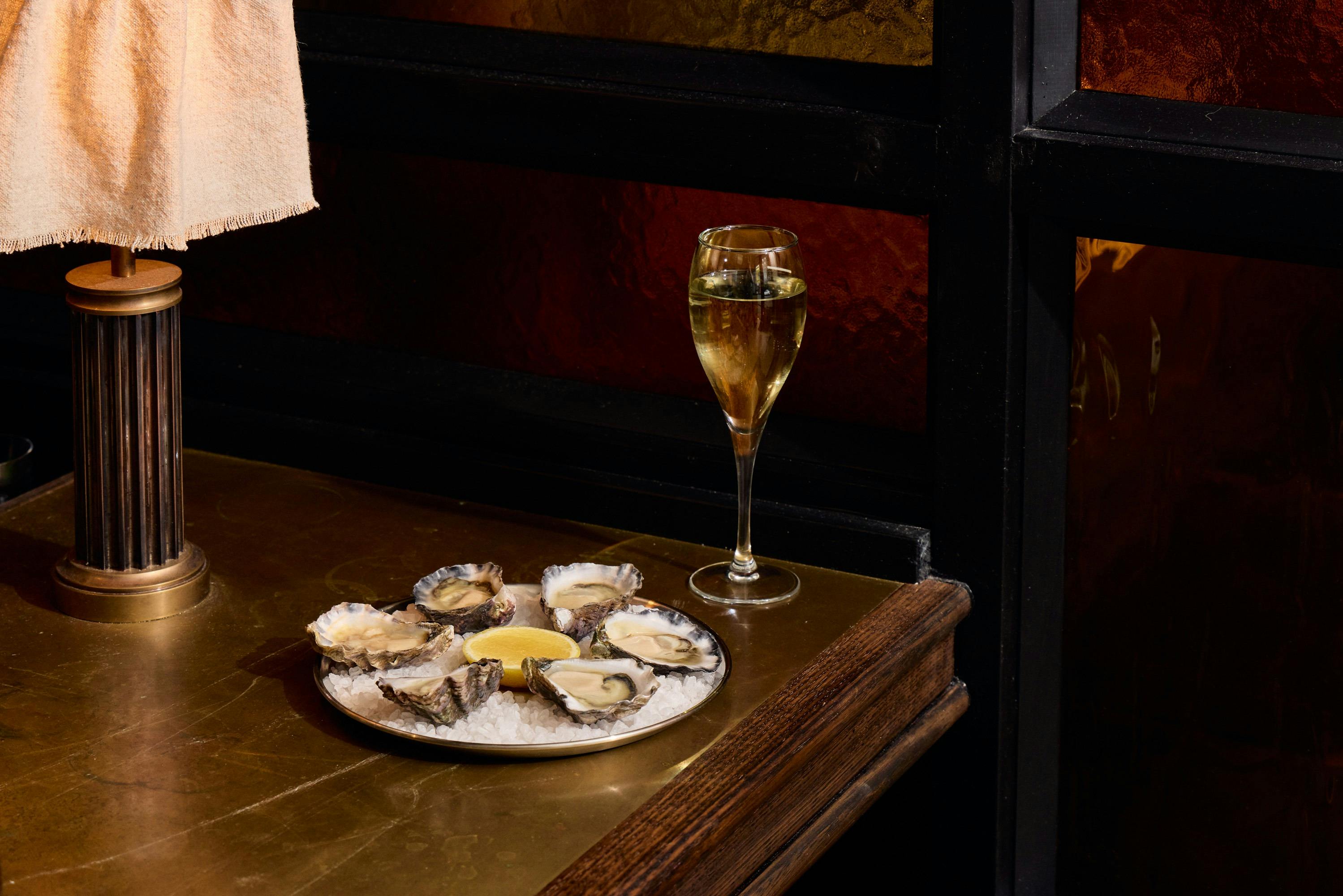 Oysters and glass of champagne on table