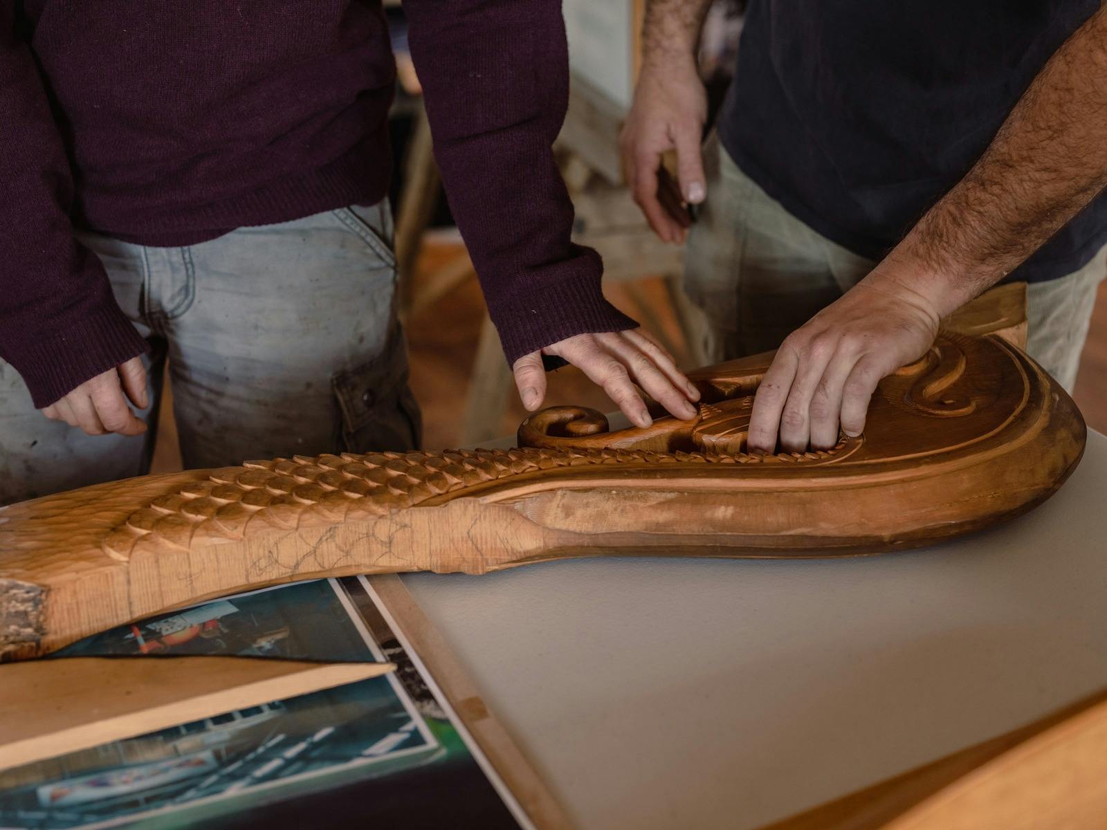 Two people touching carved wooden .