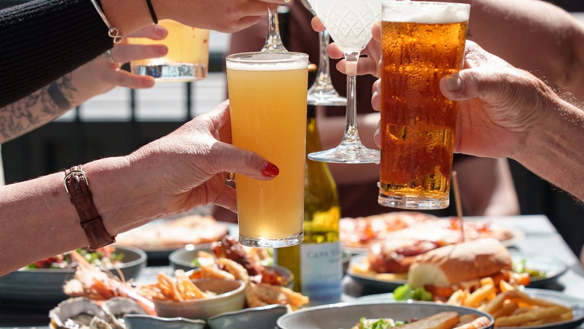 photo of people clinking their beverages over lunch at Club Whitsunday