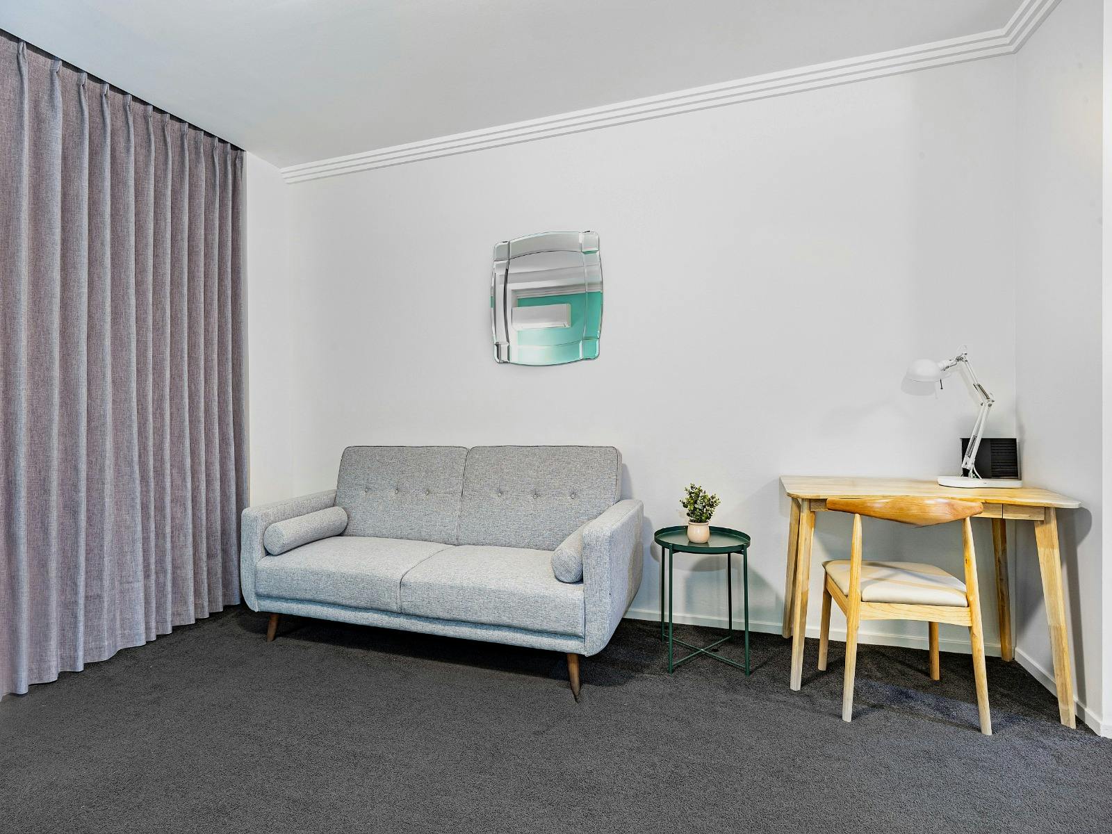 Cozy living area with a sofa bed, side table, and neutral décor.